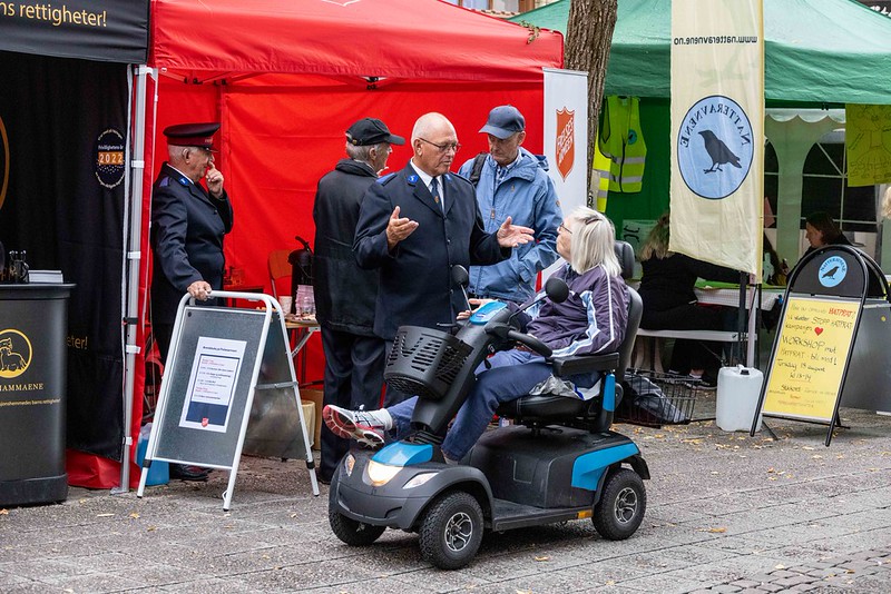 En person i elektrisk rullestol i samtale med en standsutstiller.