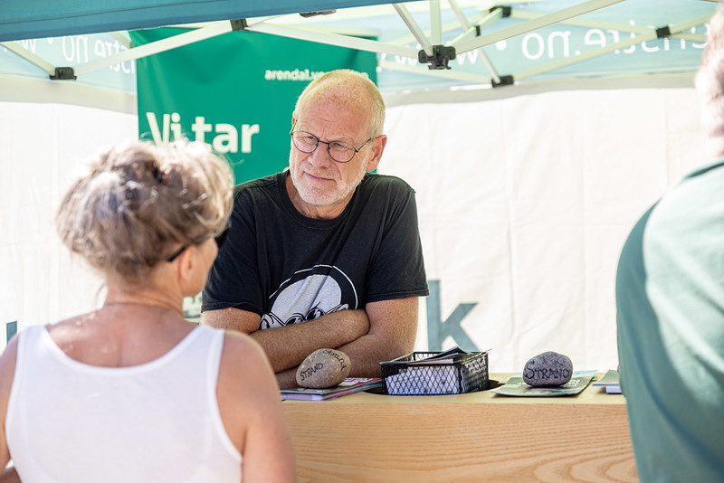 En standsutstiller i samtale med en publikumer.