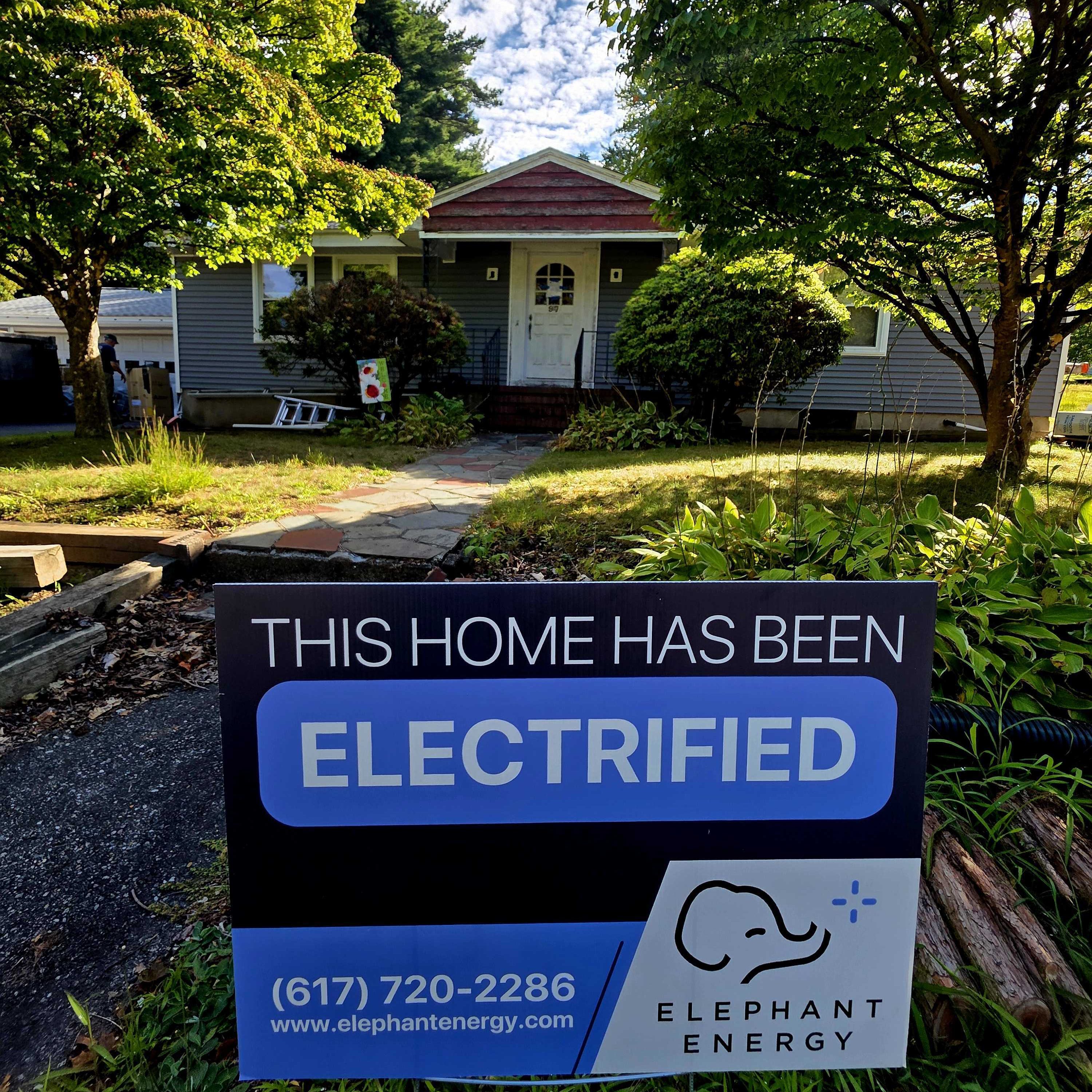 Image of an Elephant Energy yard sign in front of a home saying "This home has been electrified"