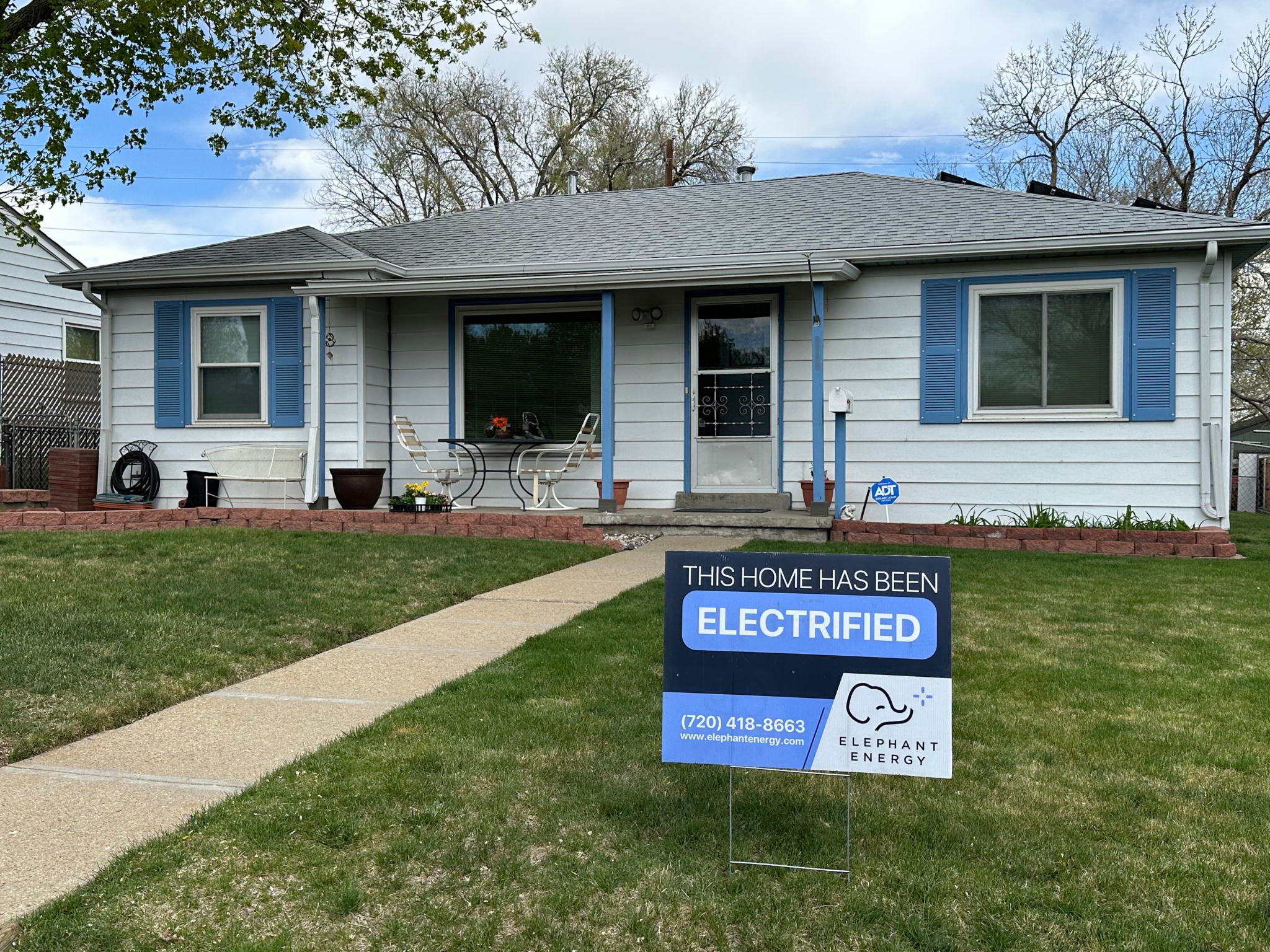 Front of home with a "this home has been electrified" yard sign in the lawn
