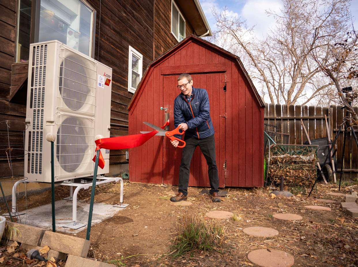 Justin Bailey, Lafayette Homeowner, cutting the ribbon to his holiday gift: a brand new cold-climate Mitsubishi Heat Pump