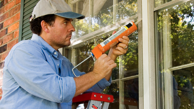 Man sealing windows