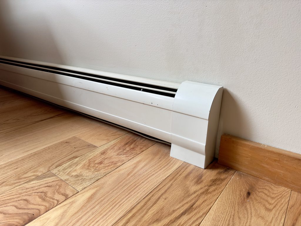 Close up of baseboard heater on the bottom of a wall