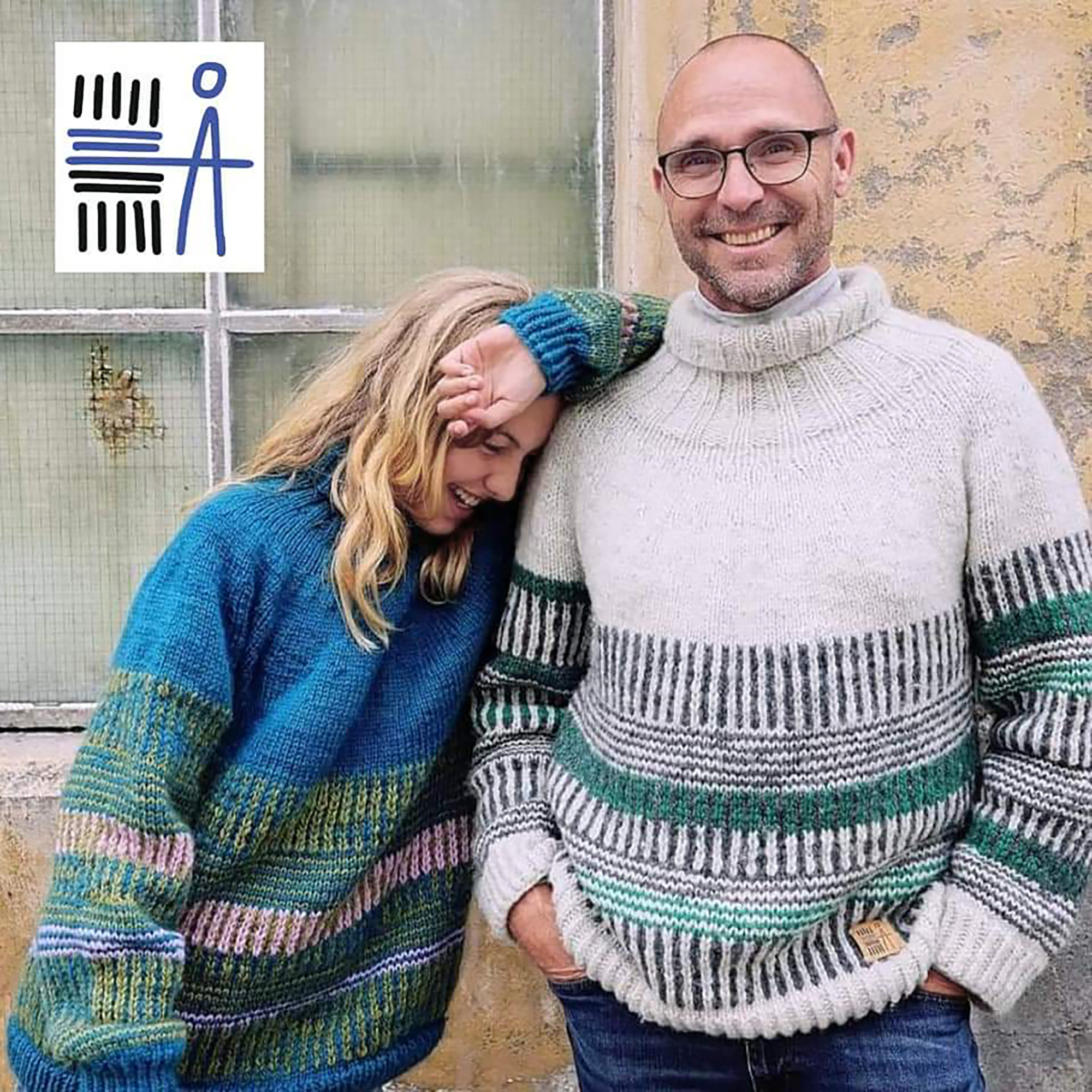 Foto: Kvinne med langt, blondt hår og skallet mann med briller står i hver sin genser. Hun lener seg mot ham og vi kan ikke se ansiktet hennes. Han ser i kamera.