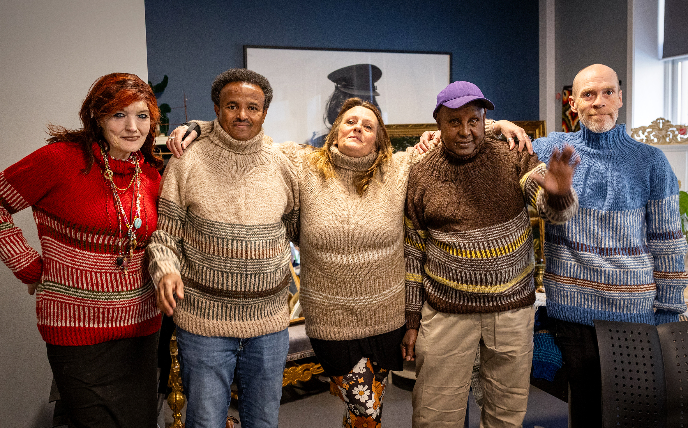 Foto: Fem personer på rekke, to kvinner og tre menn – alle i samme strikkegenser.