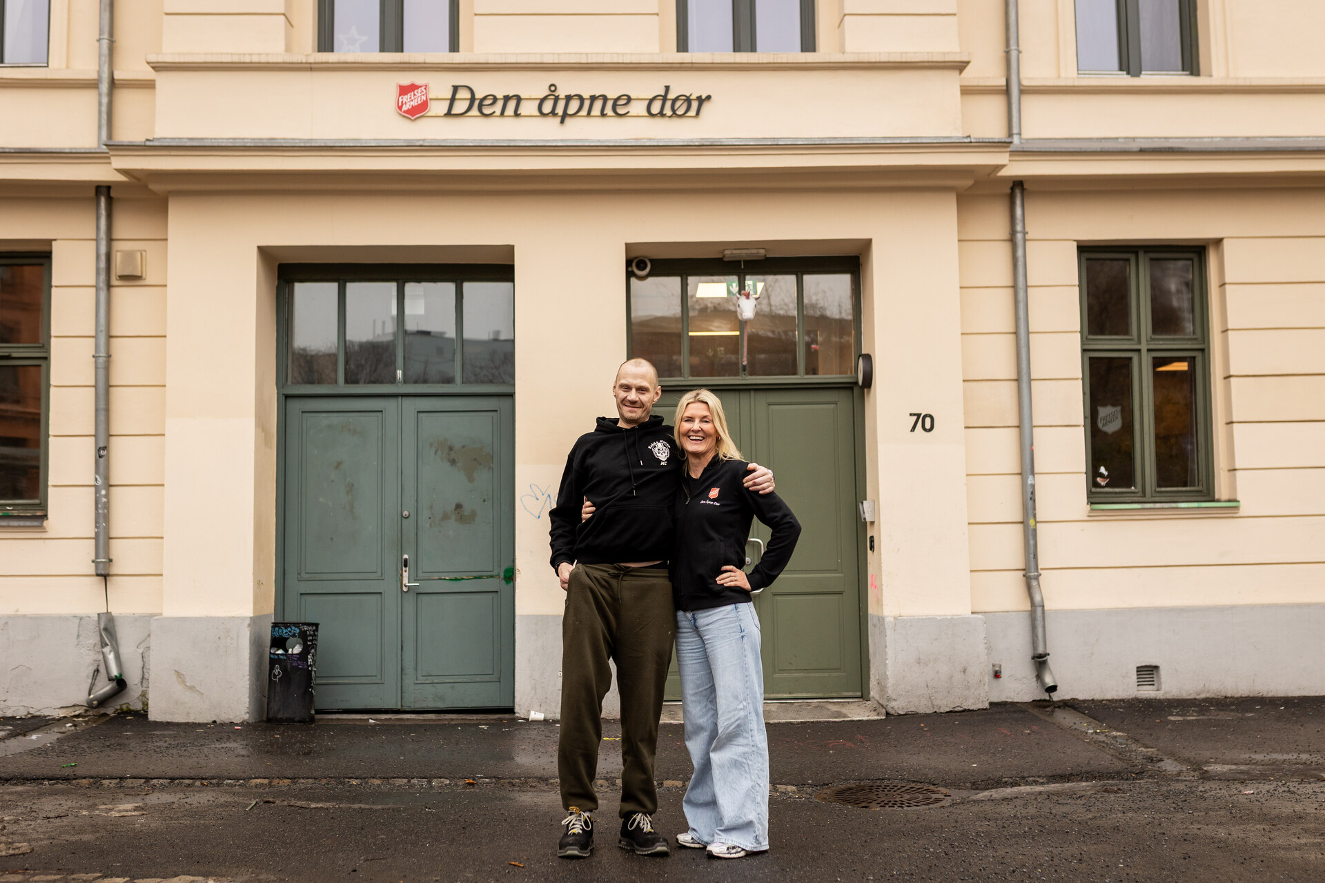Beboer på Den åpne dør, Kim Jørand, og daglig leder  Beate Haaberg Fernandez står foran inngangsdøra i Gamlebyen i Oslo