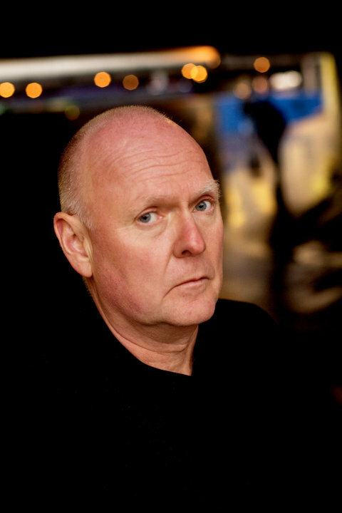 Foto: Nærbilde av mann i 60-årene uten hår på hodet. Han ser alvorlig i kamera.