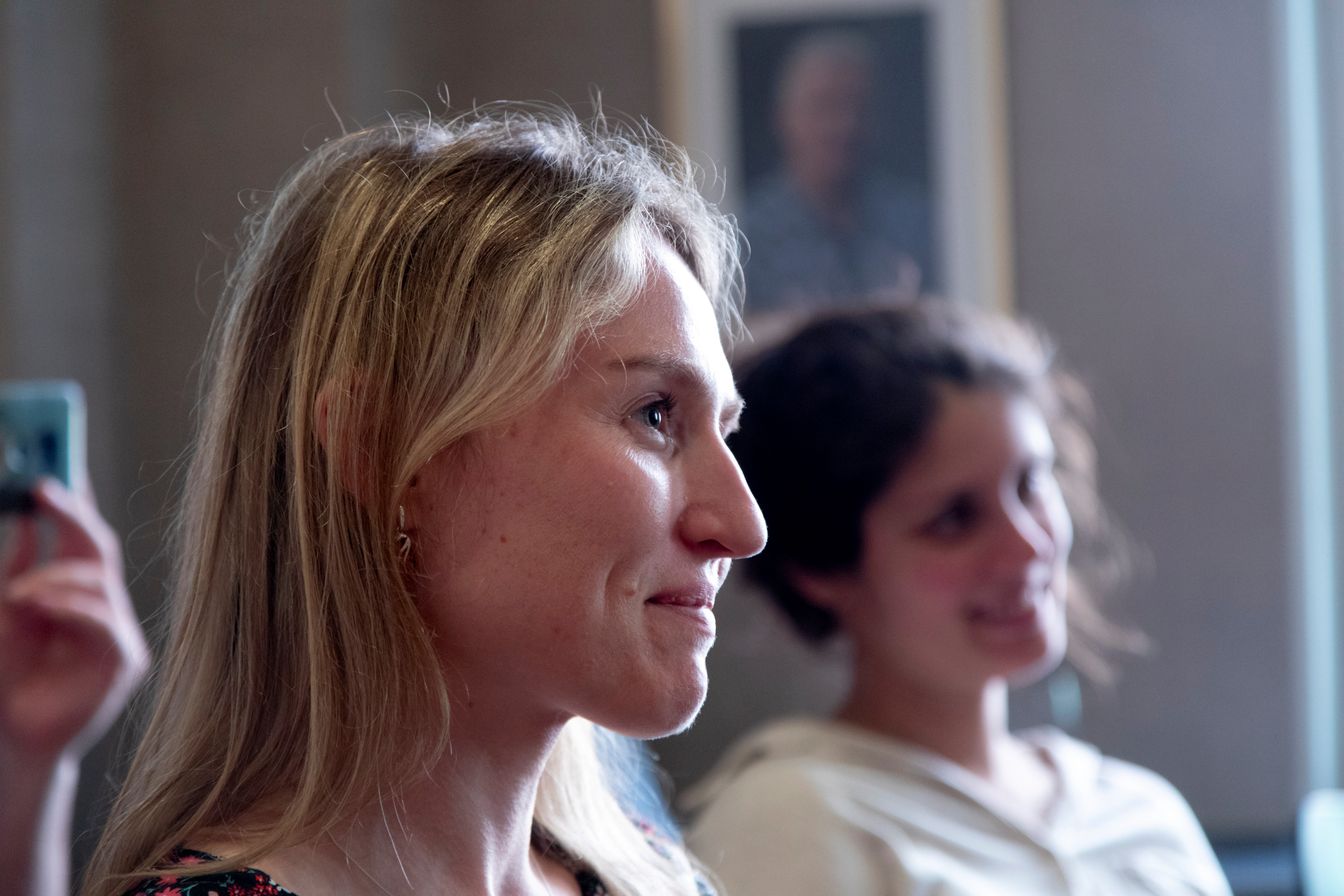 Foto: Nærbilde av kvinne som sitter i en sal og ser spent framover. Hun er i 30-årene.