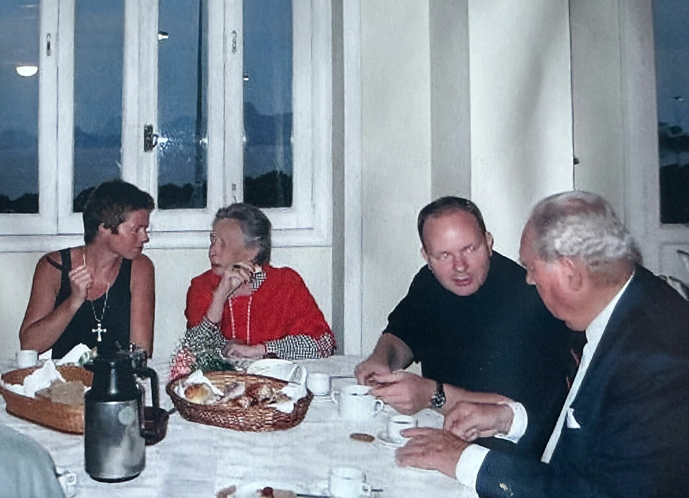 Foto: Et ungt par og et eldre par sitter ved et bord med kaker.