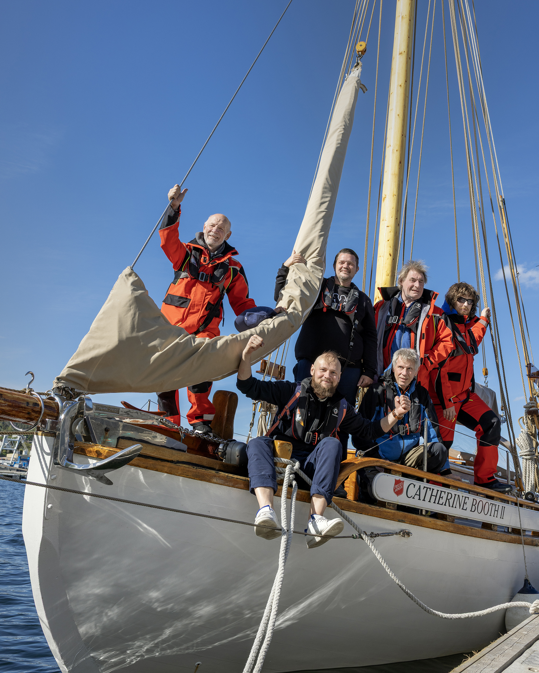Foto: Mannskapet poserer i baugen av båten når den ligger til kai med alle seil nede.