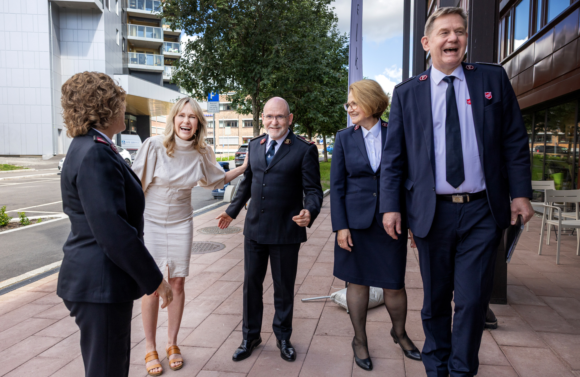 Foto: Tre kvinner og to menn er lattermilde utenfor Frelsesarmeens nye hovedkvarter i Oslo. Fire er i uniform fra Frelsesarmeen.