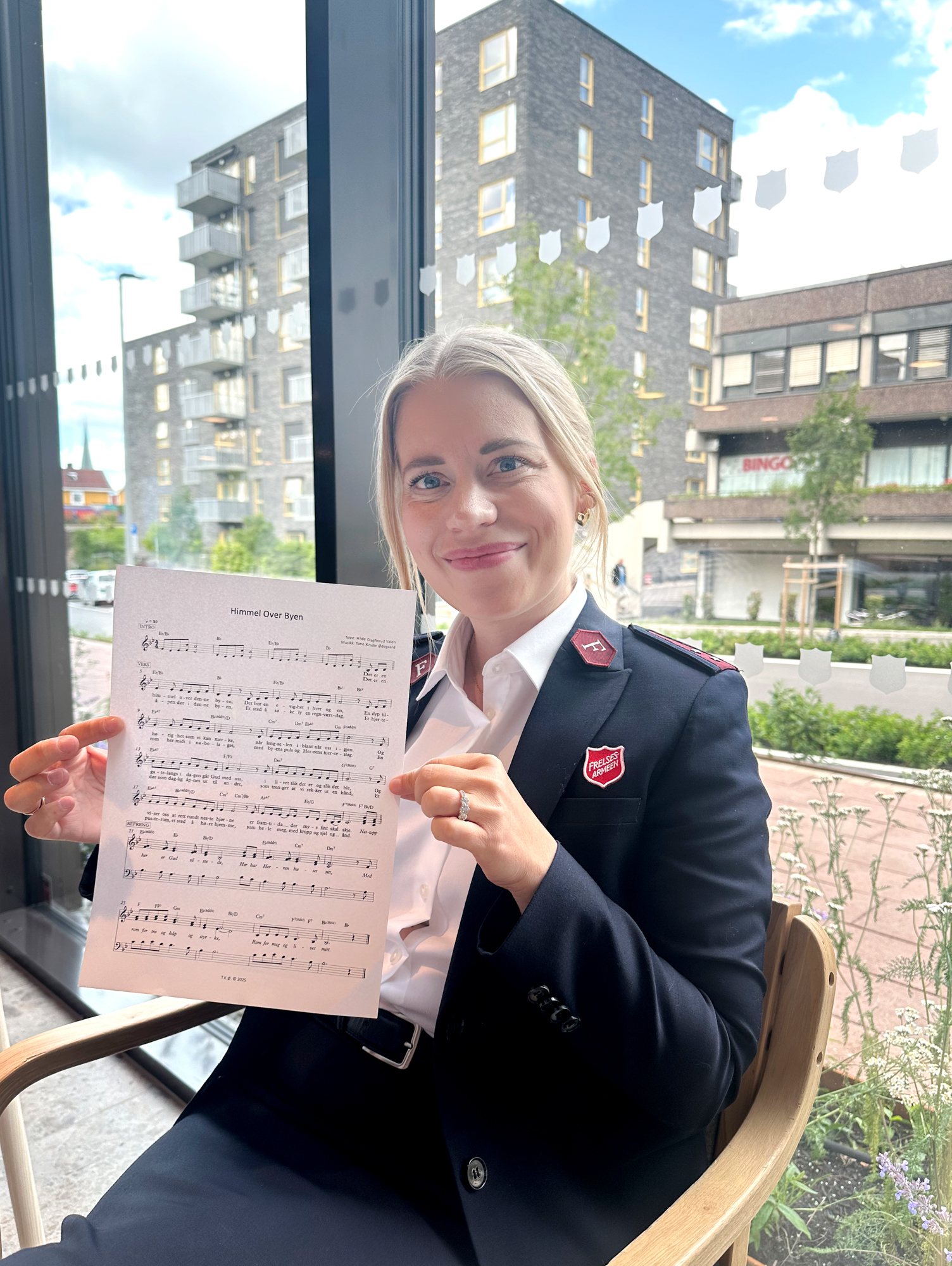 Foto: Kvinne tidlig i 40-årene holder fram et noteark.