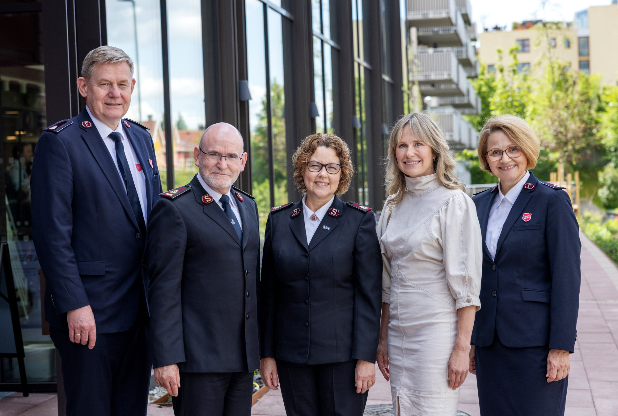 Foto: To kvinner og to menn fra Frelsesarmeen står på rekke. Blant dem står en blond kvinne i beige kjole.