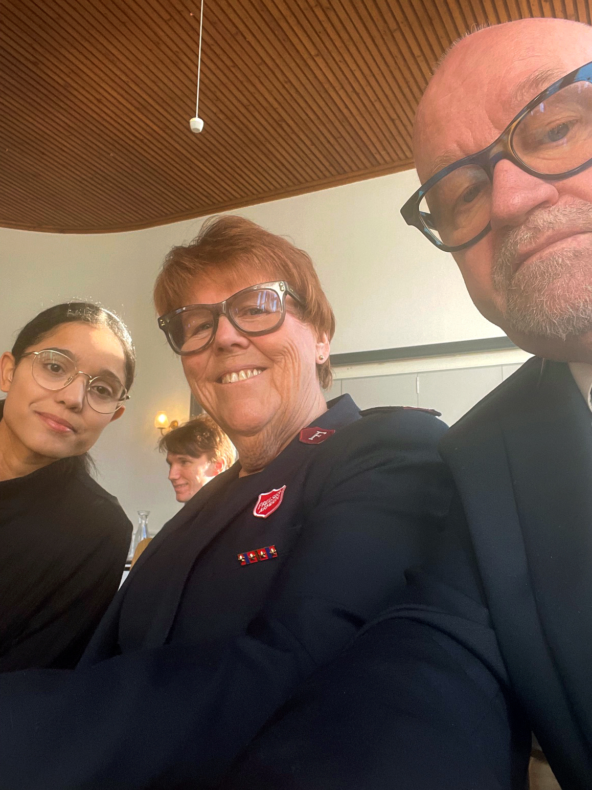 Foto: Selfie tatt av mann i 60-årene med briller og uniform fra Frelsesarmeen. Ved siden av ham står en voksen dame, også med briller og i uniform, og en tenåringsjente med mørkt hår og briller.