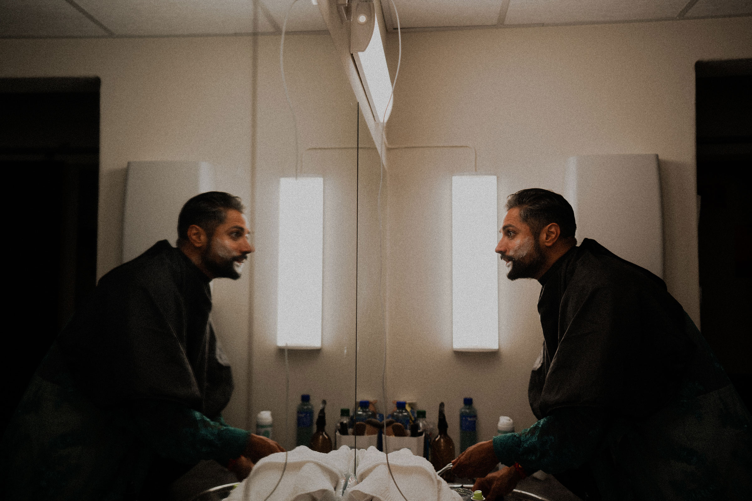 Foto: Mørk mann i 40-årene ser sin egen refleksjon i speilet mens han barberer seg. Han har fyldig hår og skjegg.