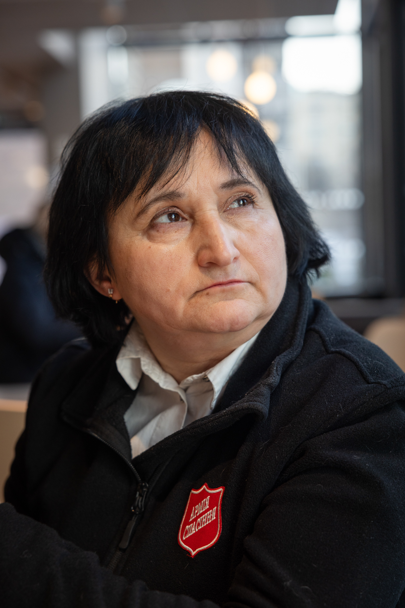 Foto: Kvinne i 50-årene med mørkt hår i blå uniform.