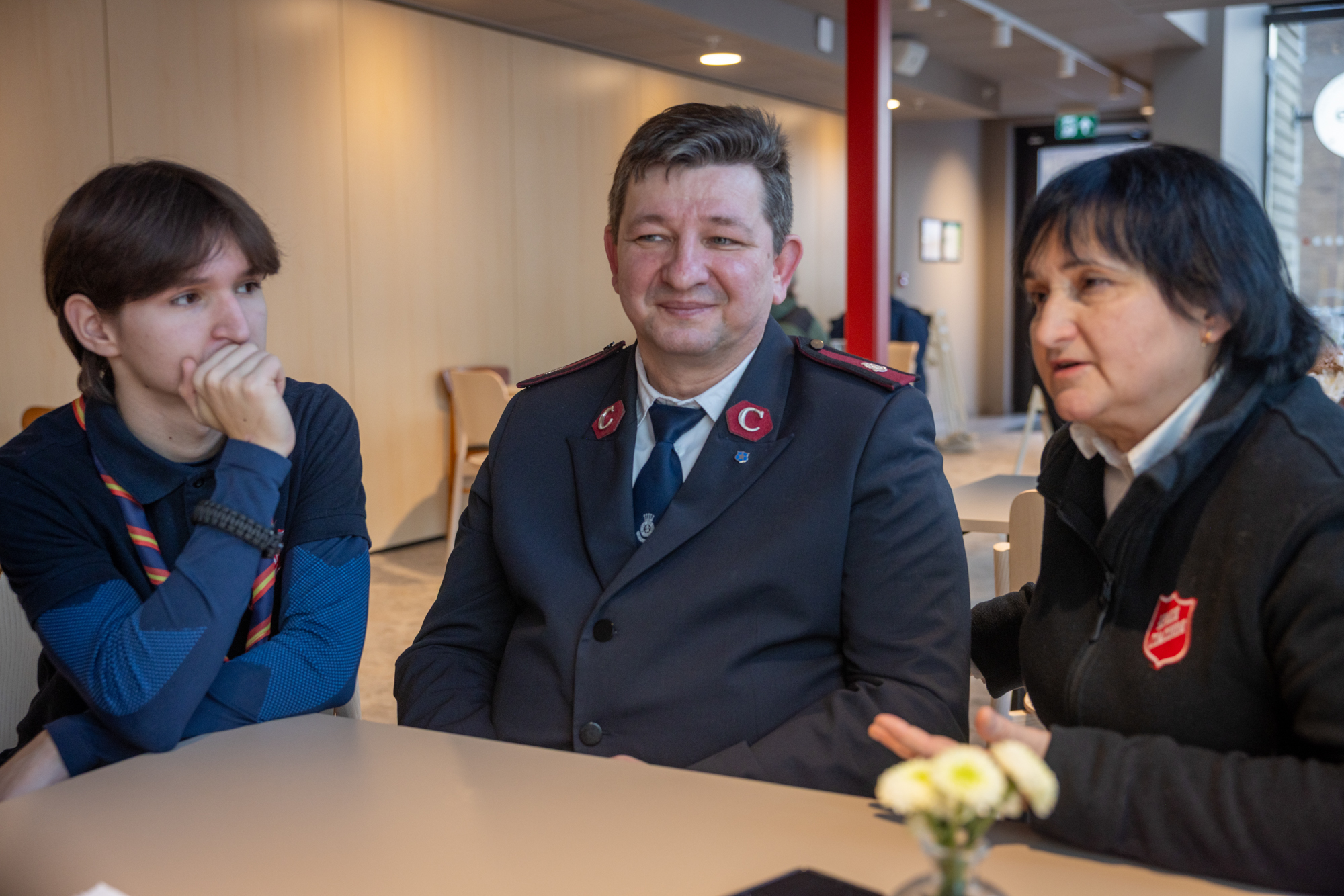 Foto: Tenåringsgutt sammen med voksen kvinne og mann – begge i uniform fra Frelsesarmeen.