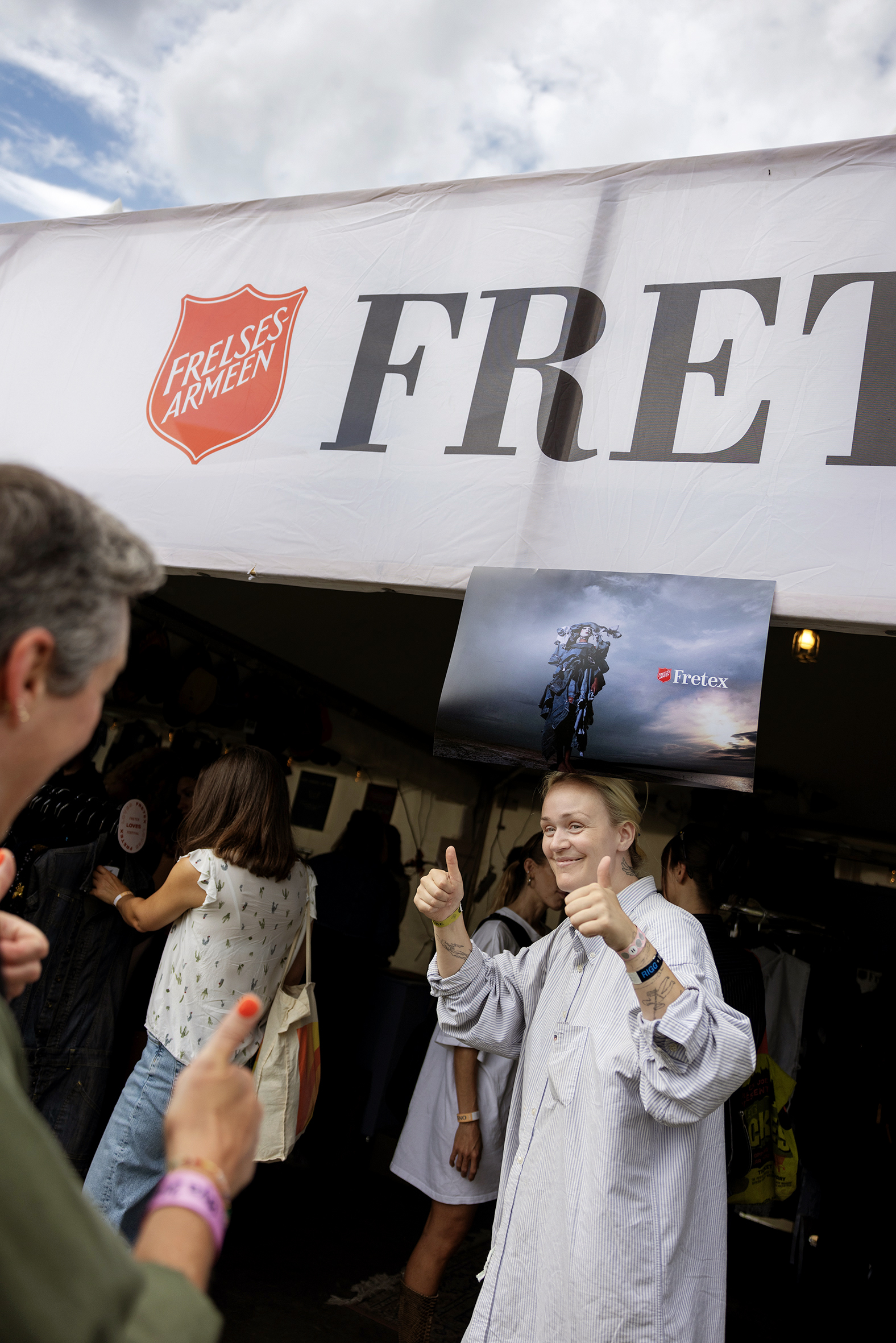 Foto: Kvinne på vei inn i butikk med tommelen opp.