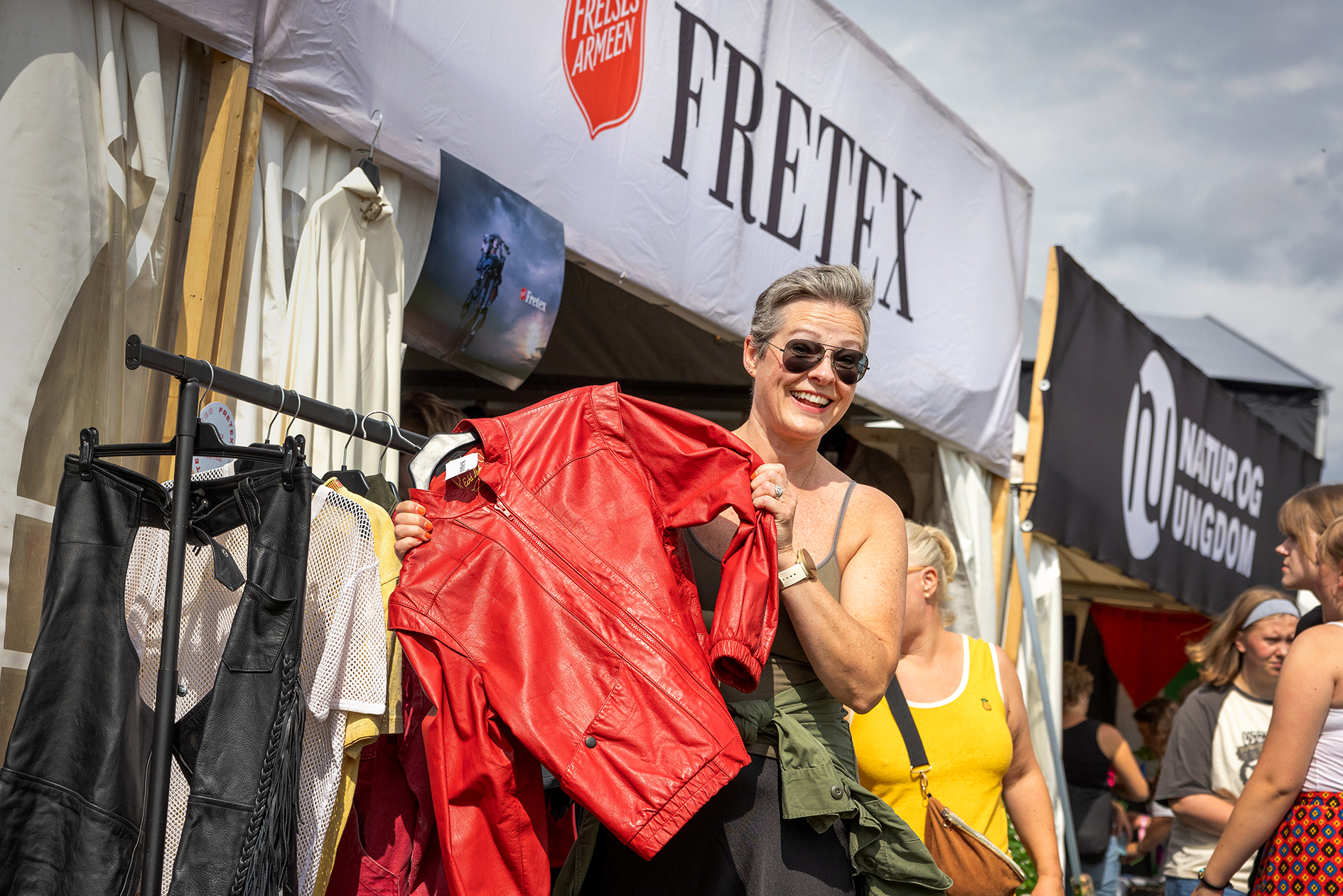 Foto: av kvinne i 50-årene som holder opp en brukt, rød skinnjakke.