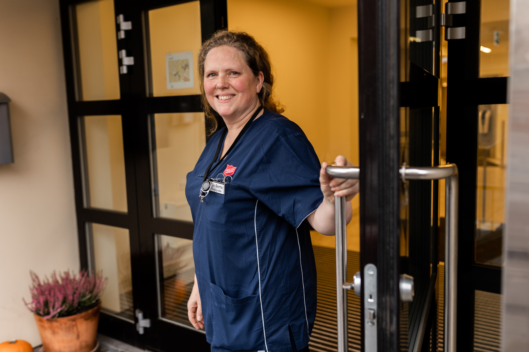 Kvinne holder en åpen dør