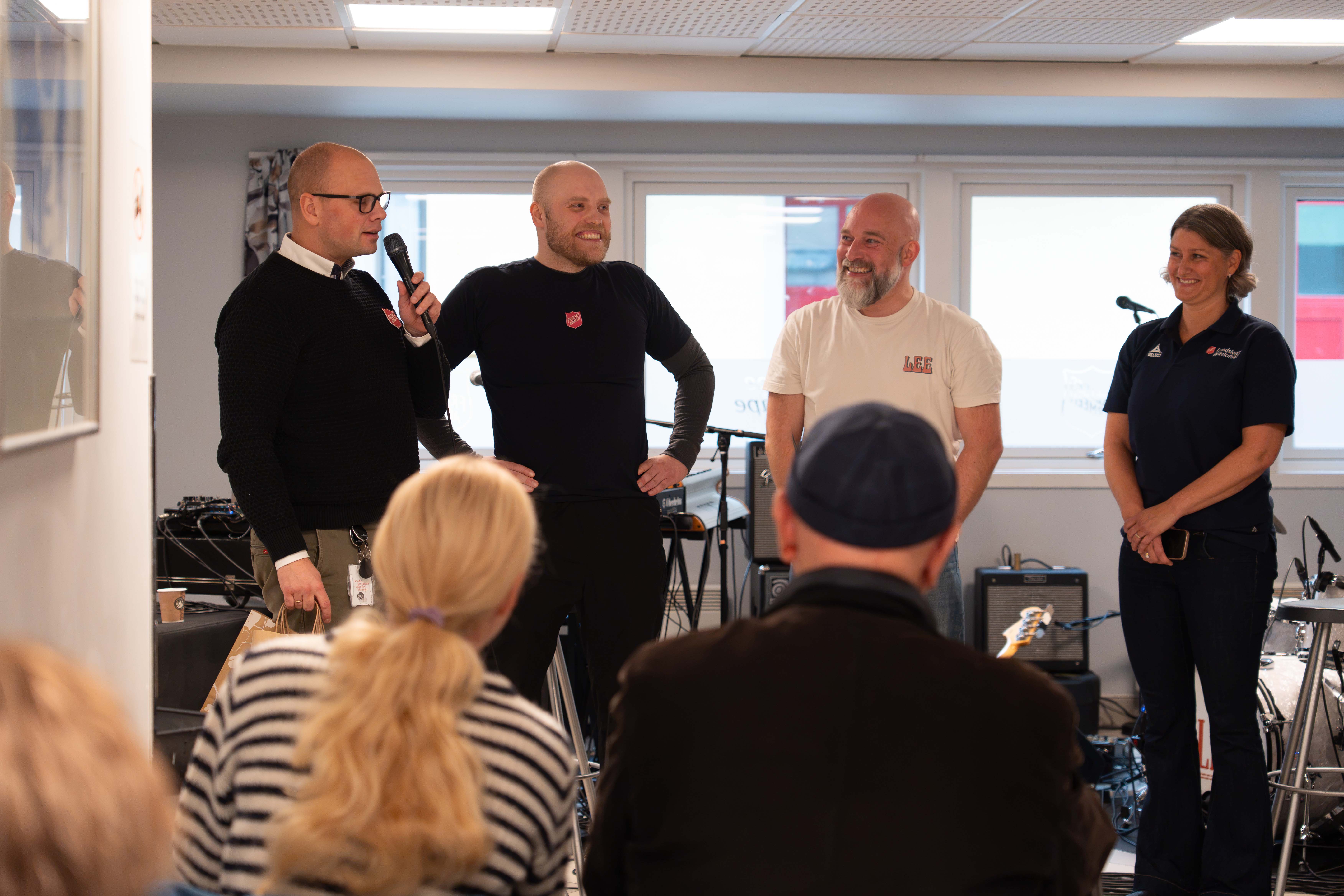 Områdeleder for Frelsesarmeneens rusomsorg, Benjamin Brekke-Nærstad, takker bidragsyterne av Gatepoddens lansering på Fyrlyset. Fra ventsre er Benjamin, Rune, Joakim og Signe.