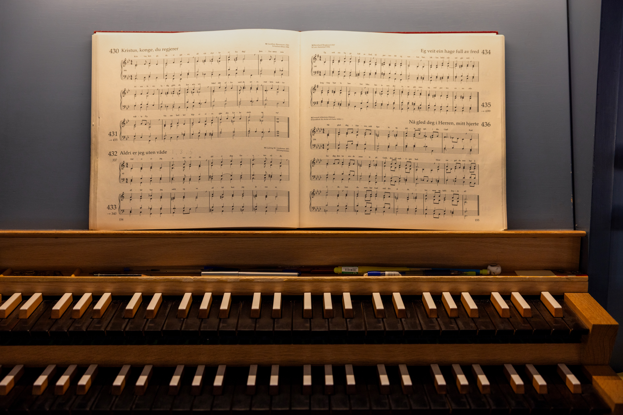 Nærbilde av orgel med tangenter og noteark.