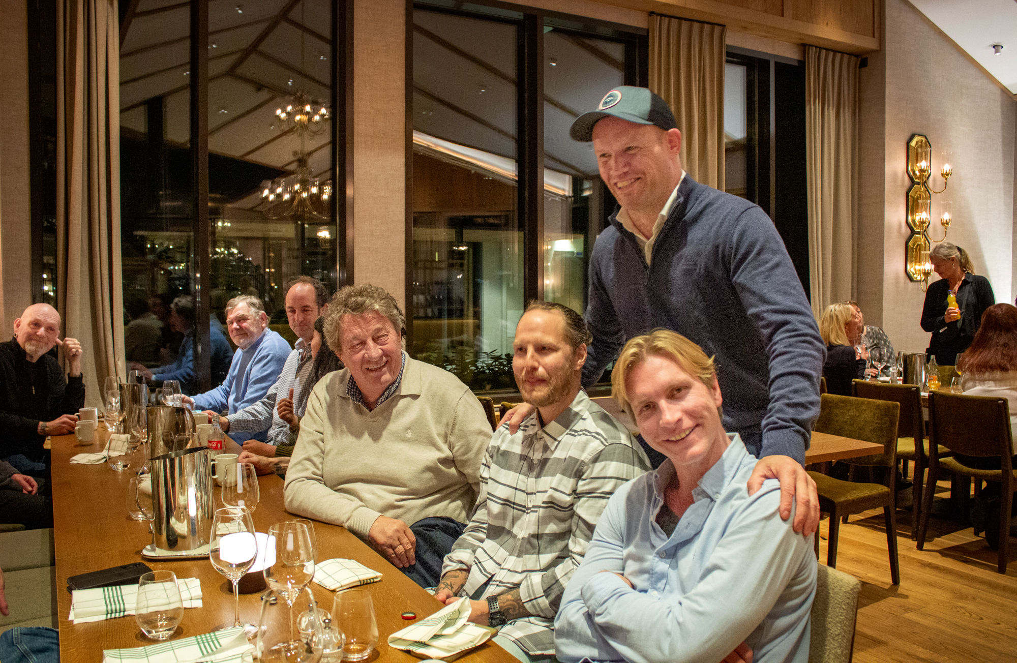 Et langbord på restaurant der ni personer er fotografert.