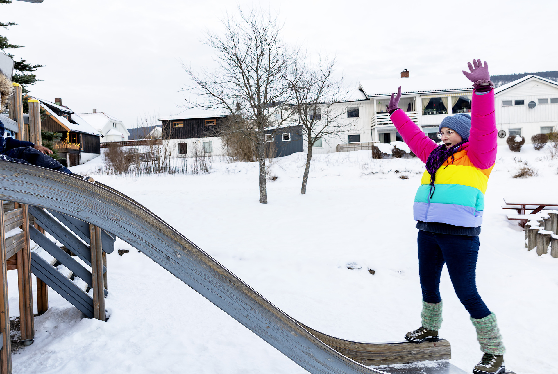 Foto: Dame i flerfarget boblejakke står ved enden av en rutsjebane.