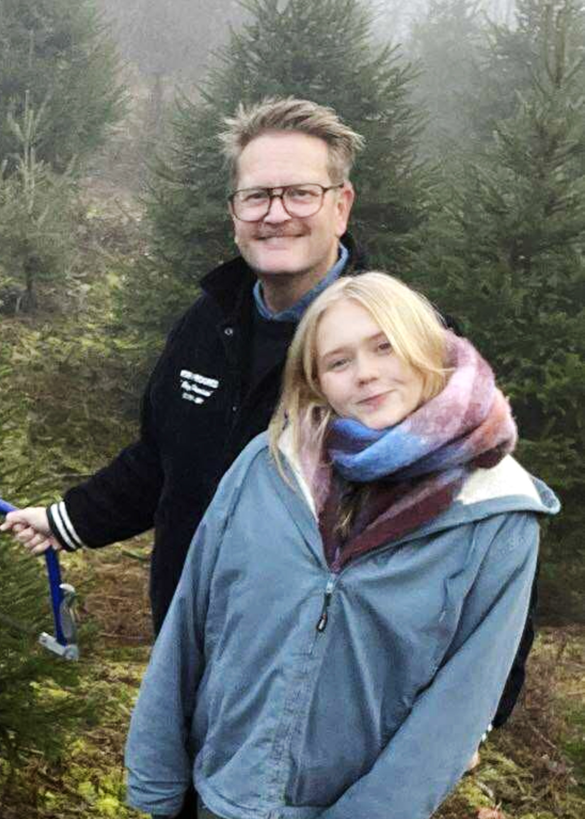 Foto: Mann i 40-årene med briller står sammen med en tenåring med langt blondt hår. De er på tur i skogen.