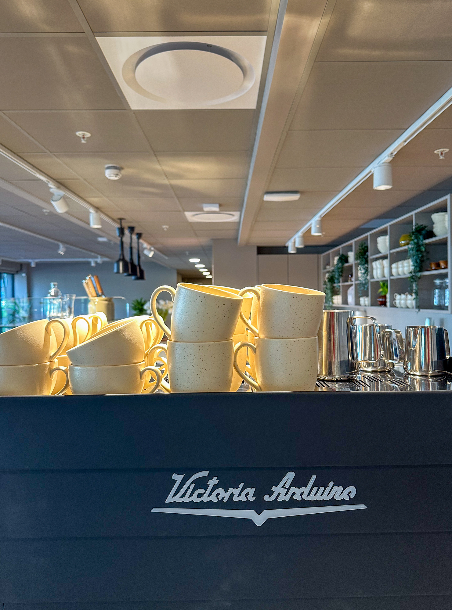 Foto: Kaffekopper stablet oppå en diger, grå kaffemaskin.