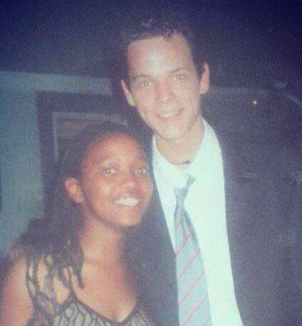 Tenåringer står tett sammen – hun med rastafletter og pen kjole, han med dress og slips.