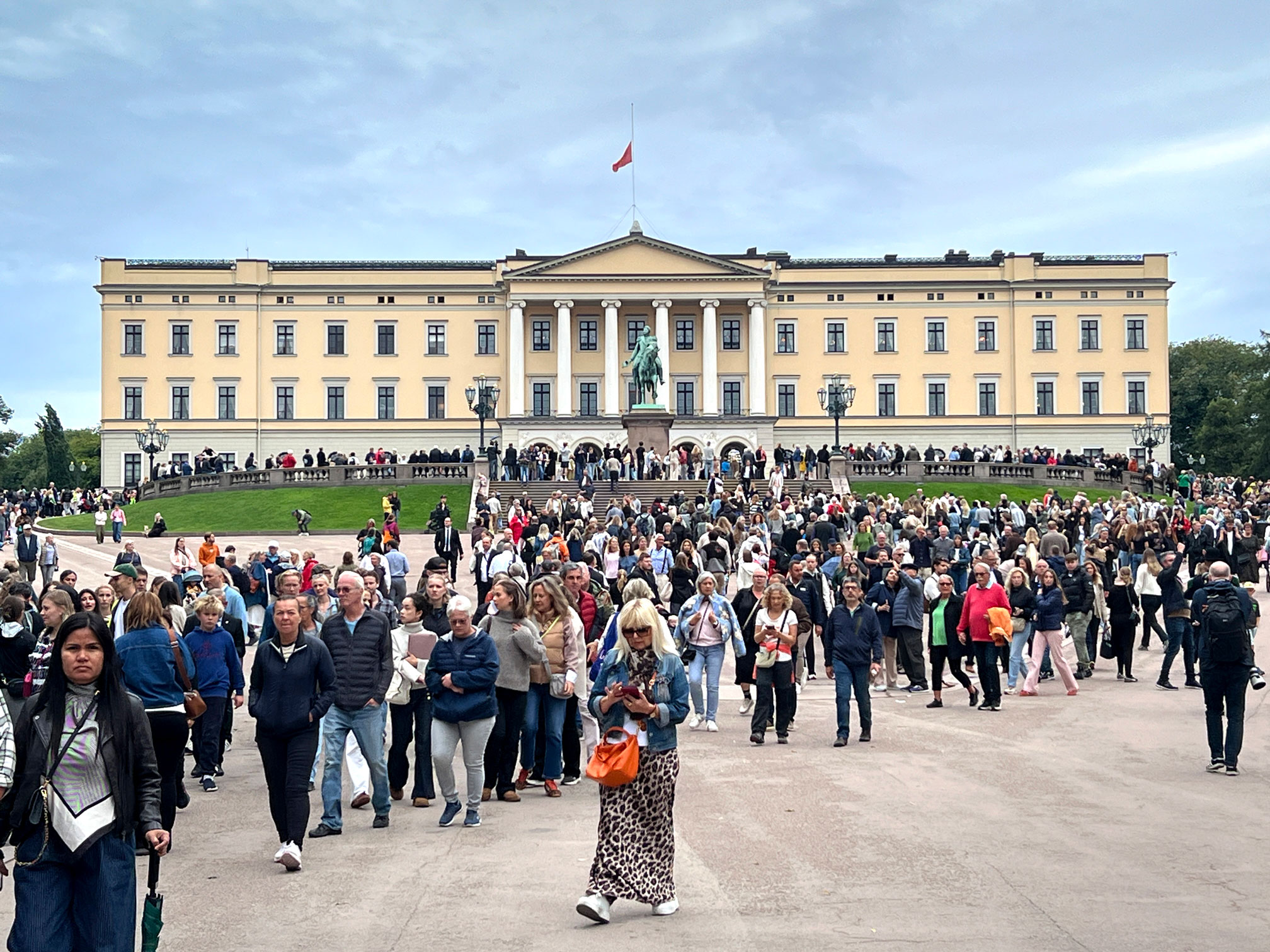Foto: Et stor, gul murbygning der det kryr av mennesker på den enorme plassen utenfor.