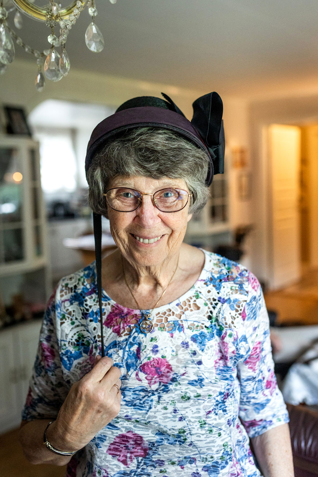 Foto: Kvinne holder i en en snor om henger ned i en hatt hun har på hodet.