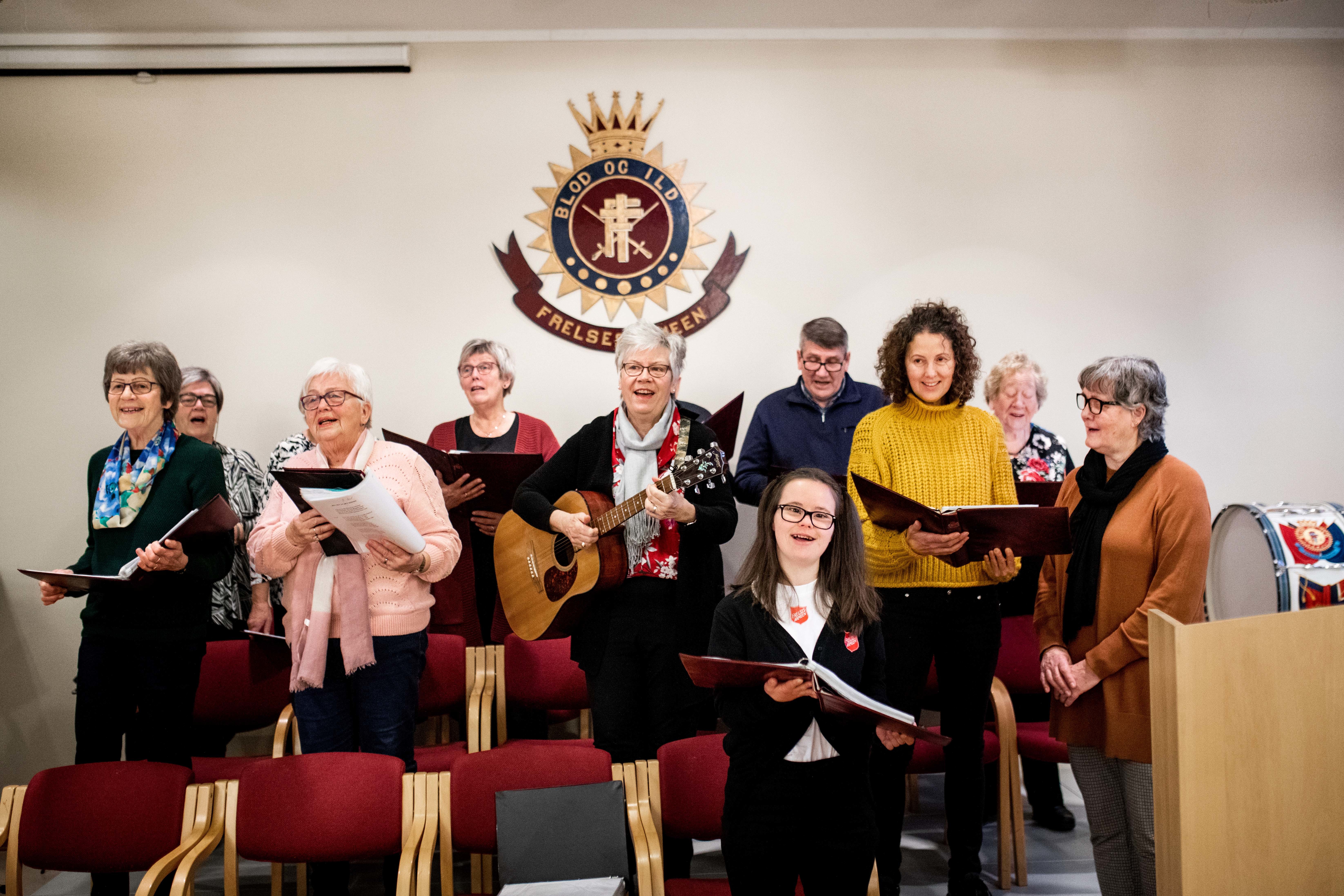 Lydia Marie Palm står og synger på korøvelsen midt i blant resten av gjengen i koret «Treffmusikken». De øver på Frelsesarmeens korps i Nedre Eiker.