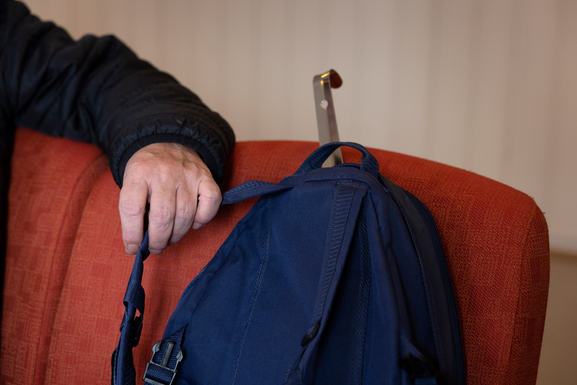 Frank sitter på sofaen, med sekken ved siden av. Han forteller om en tøff tilværelse etter at han ble syk.