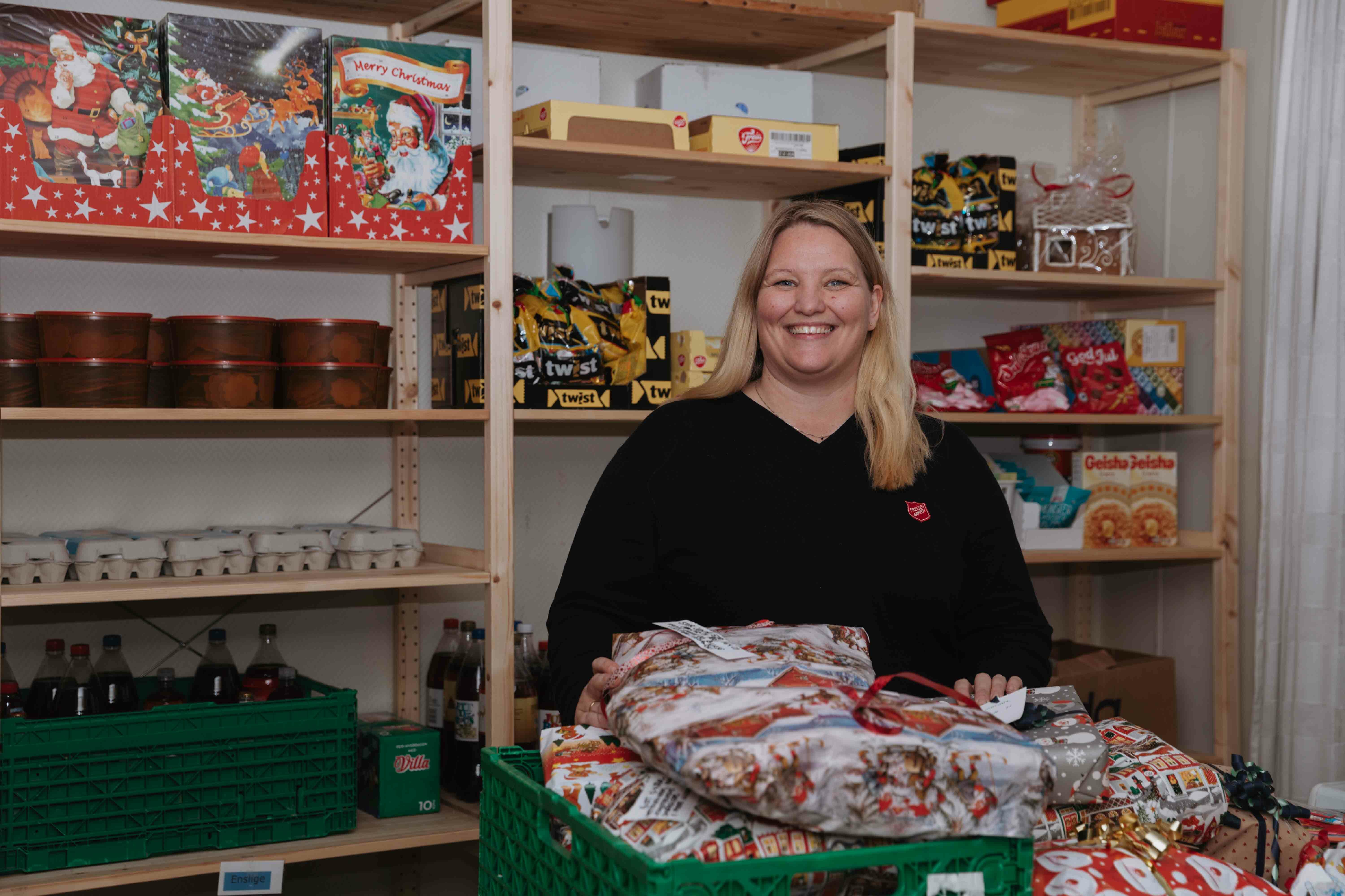 Foto: To bilder etter hverandre, der det første viser en blond dame som står med matvarer i bakgrunnen og innpakkede julegaver i en kasse foran seg. På det andre bildet vises strikkeklær som folk har laget og gitt til Frelsesarmeen.