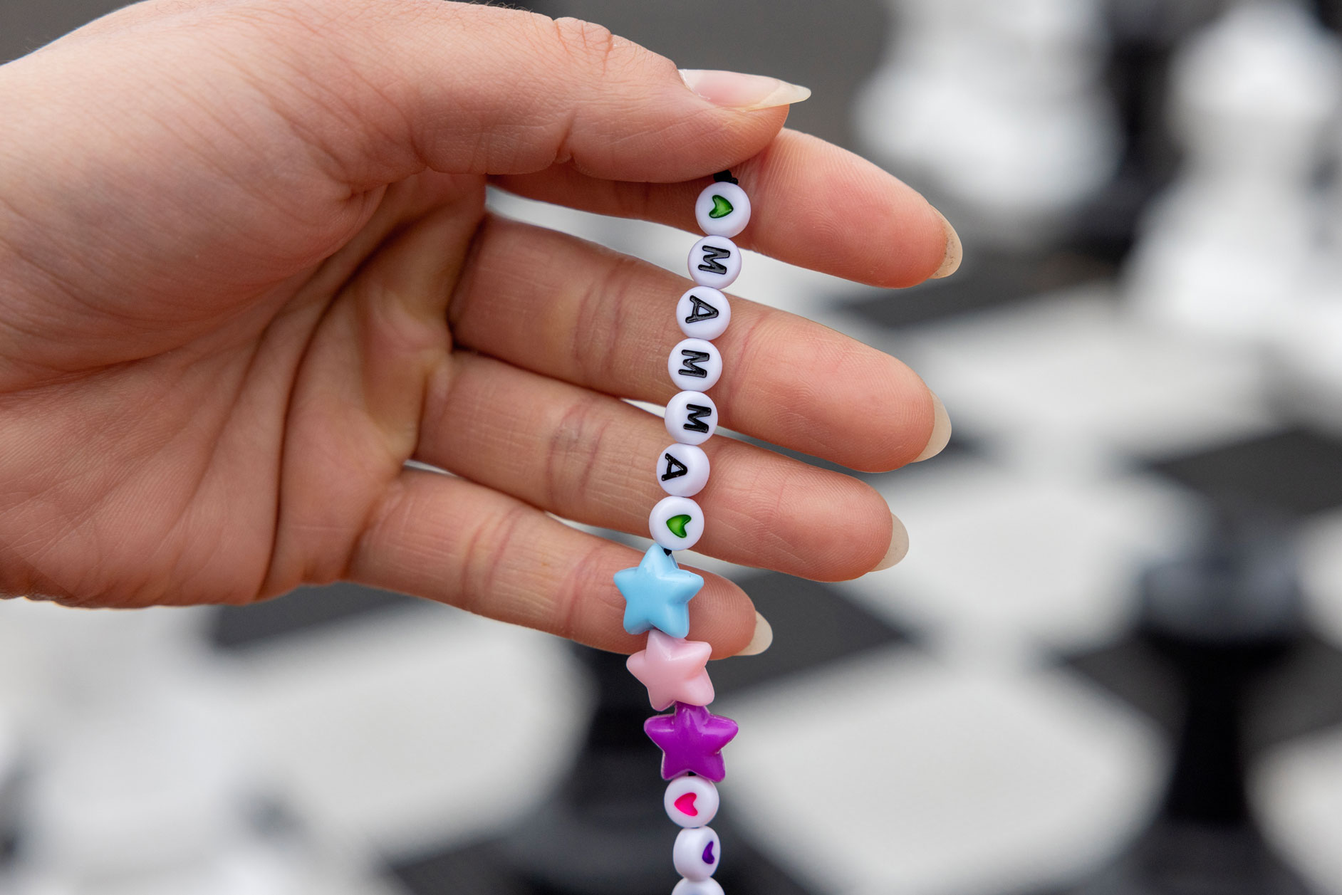 Foto: Fargerike perler i et armbånd som danner ordene mamma.
