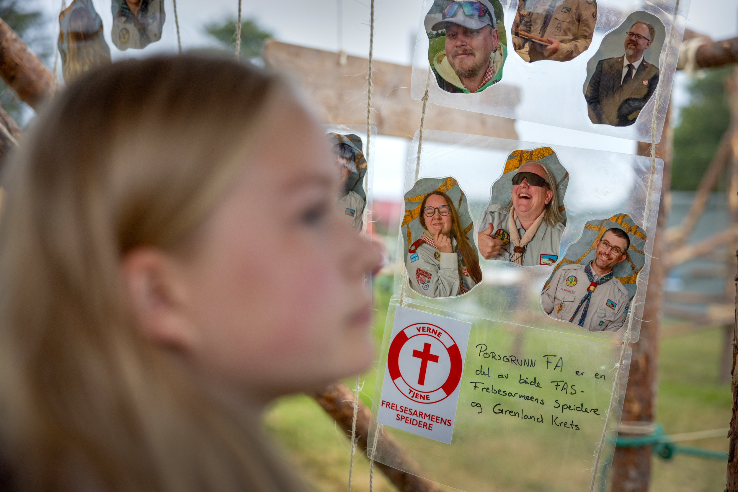 Foto: Jente litt ute av fokus ser på alle bildene som henger ned i portalen av Frelsesarmeens speidere.