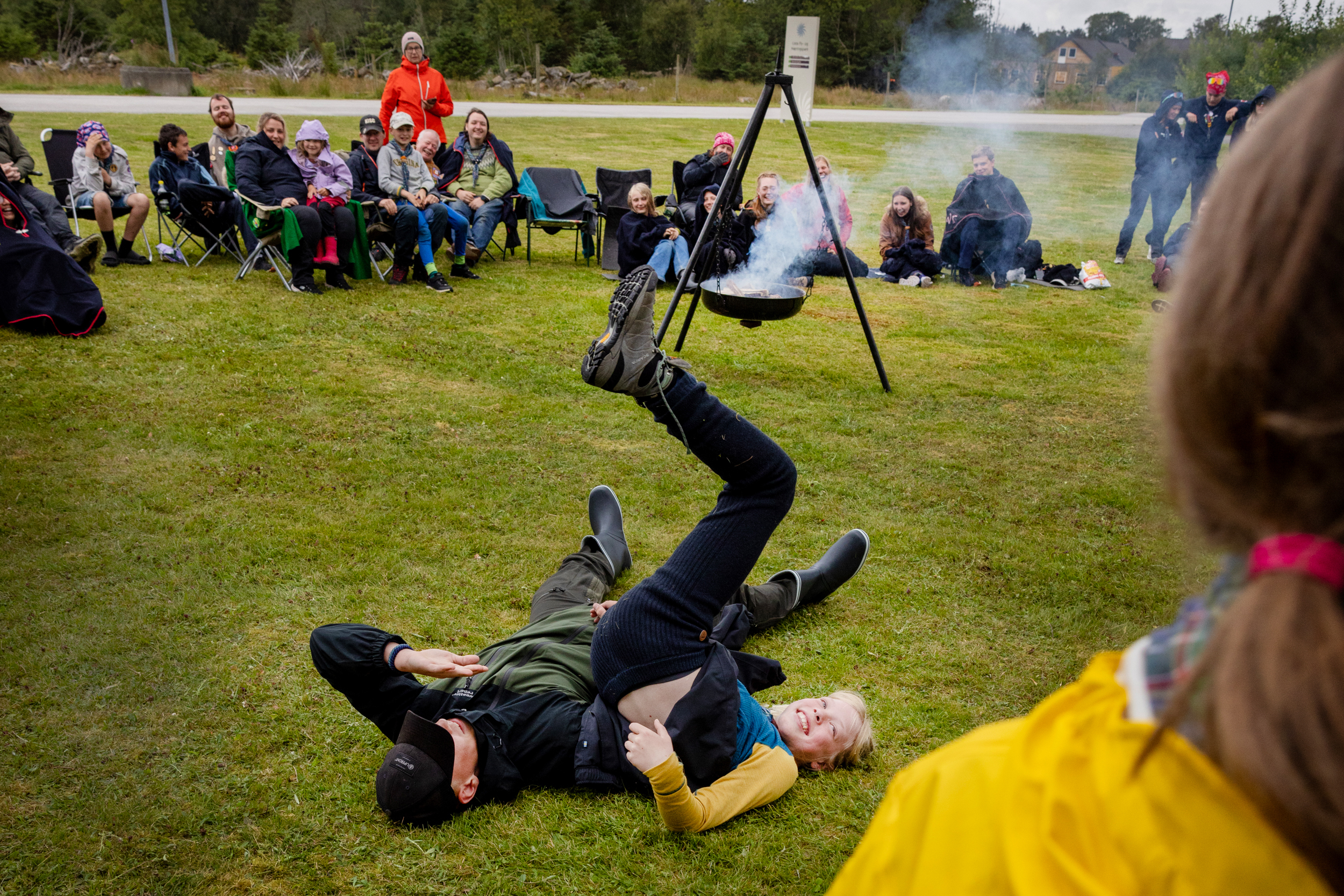 Foto: To gutter ligger på marka og måler styrke med beina.