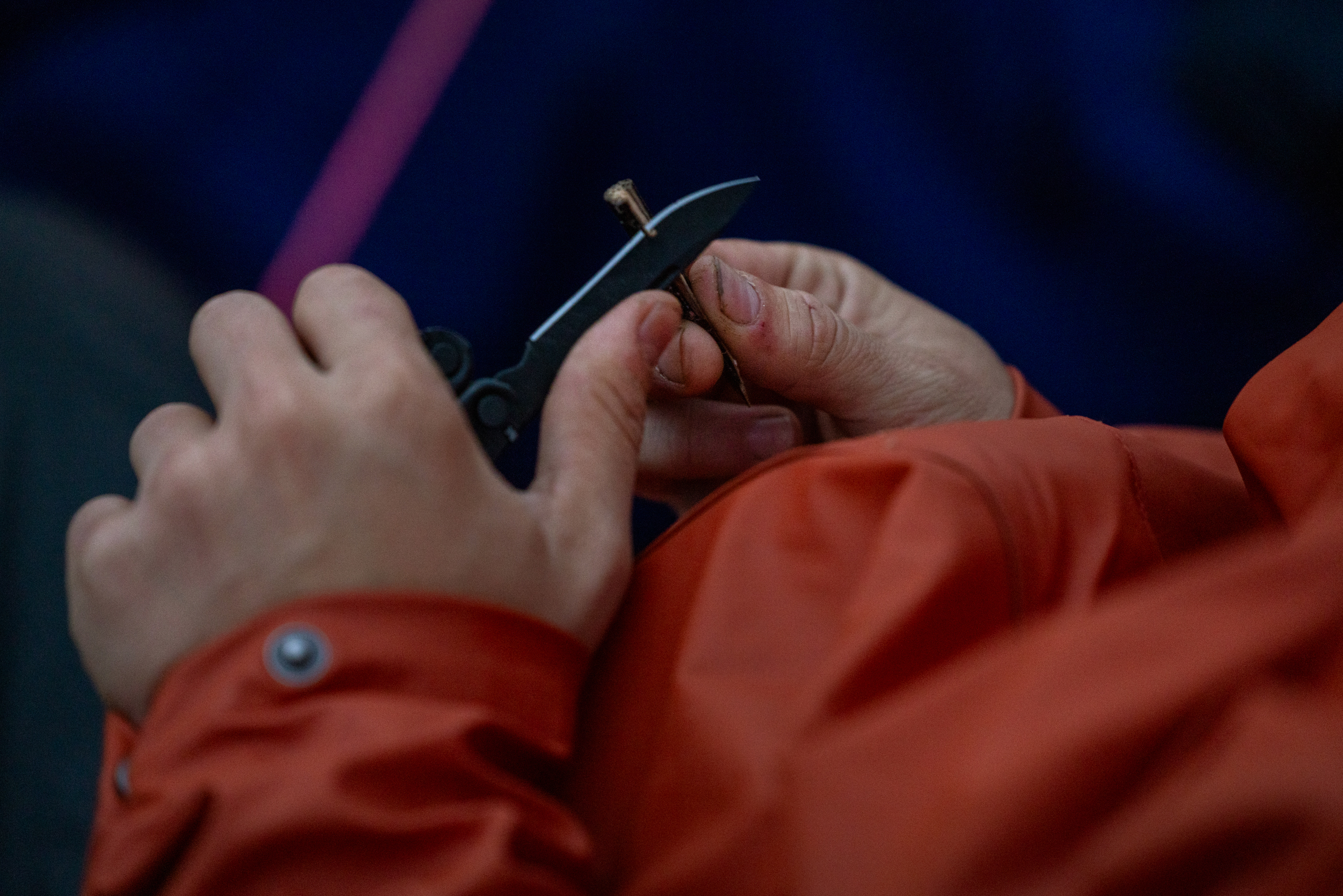 Foto: Hender som holder en kniv og en pinne. Det spikkes.