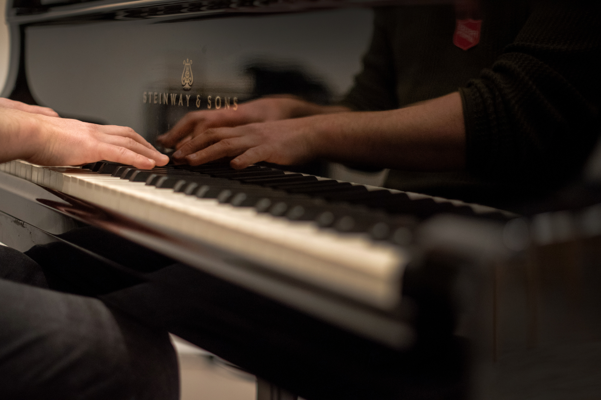 Foto: Hender til en mann som spiller på pianotangenter.