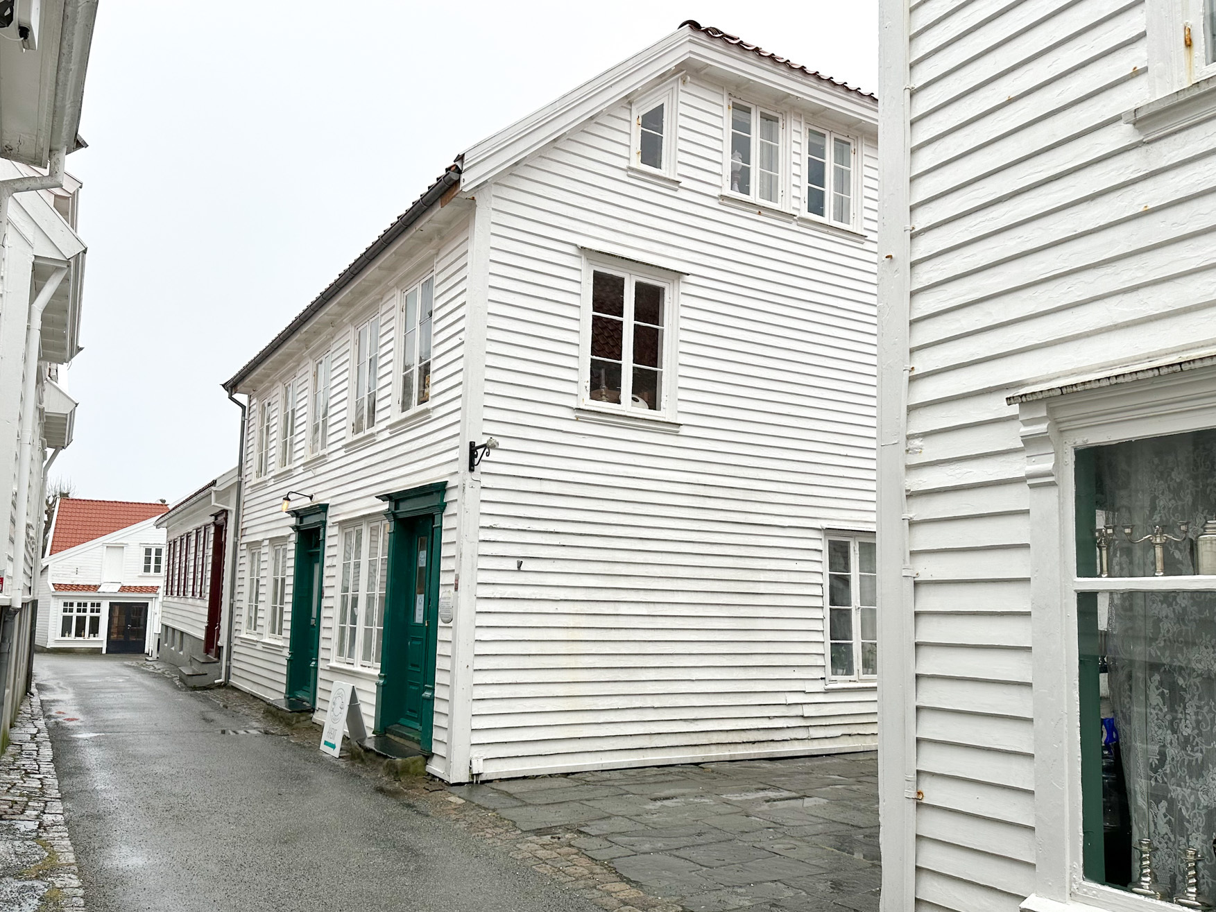 Stort, gammelt hus i gate omringet av andre gamle hus.