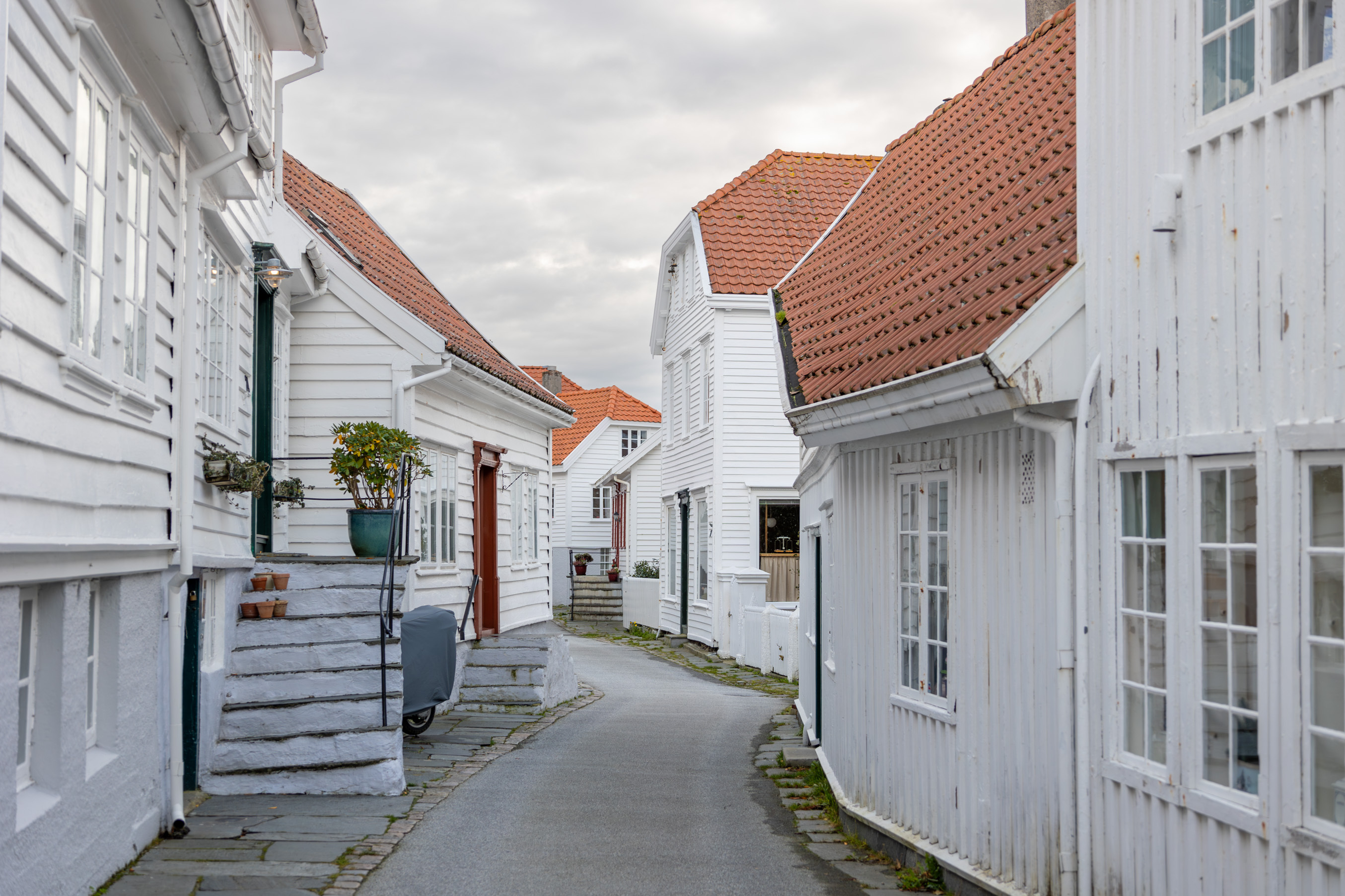En smal gate med en rekke små, hvite hus bortover.