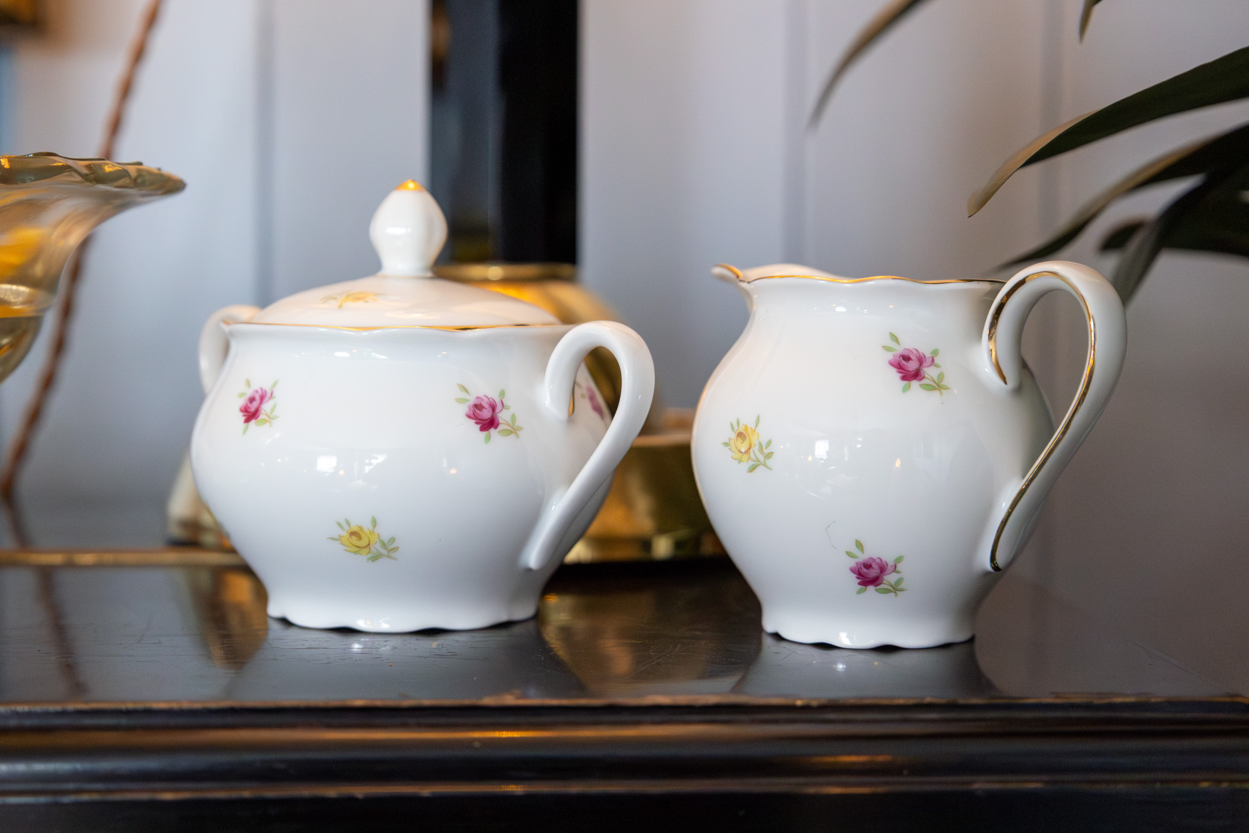 Gammelt servise i hvitt med små blomster på. Her vises sukkerskålen og fløtemuggen.