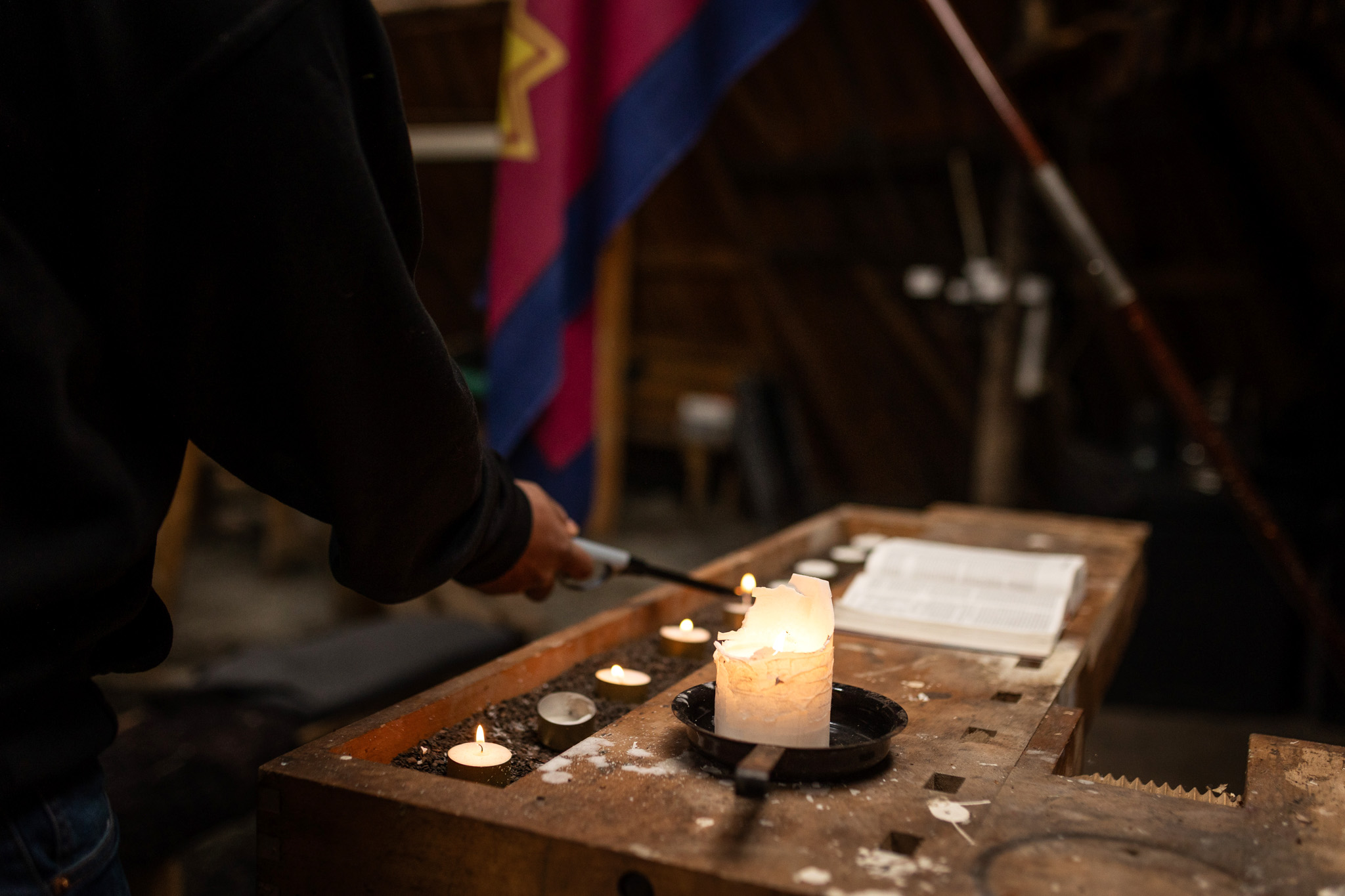 Foto: en høvelbenk med hvite talglys. Frelsesarmeens flagg i rødt, blått og gult sees i bakgrunnen.