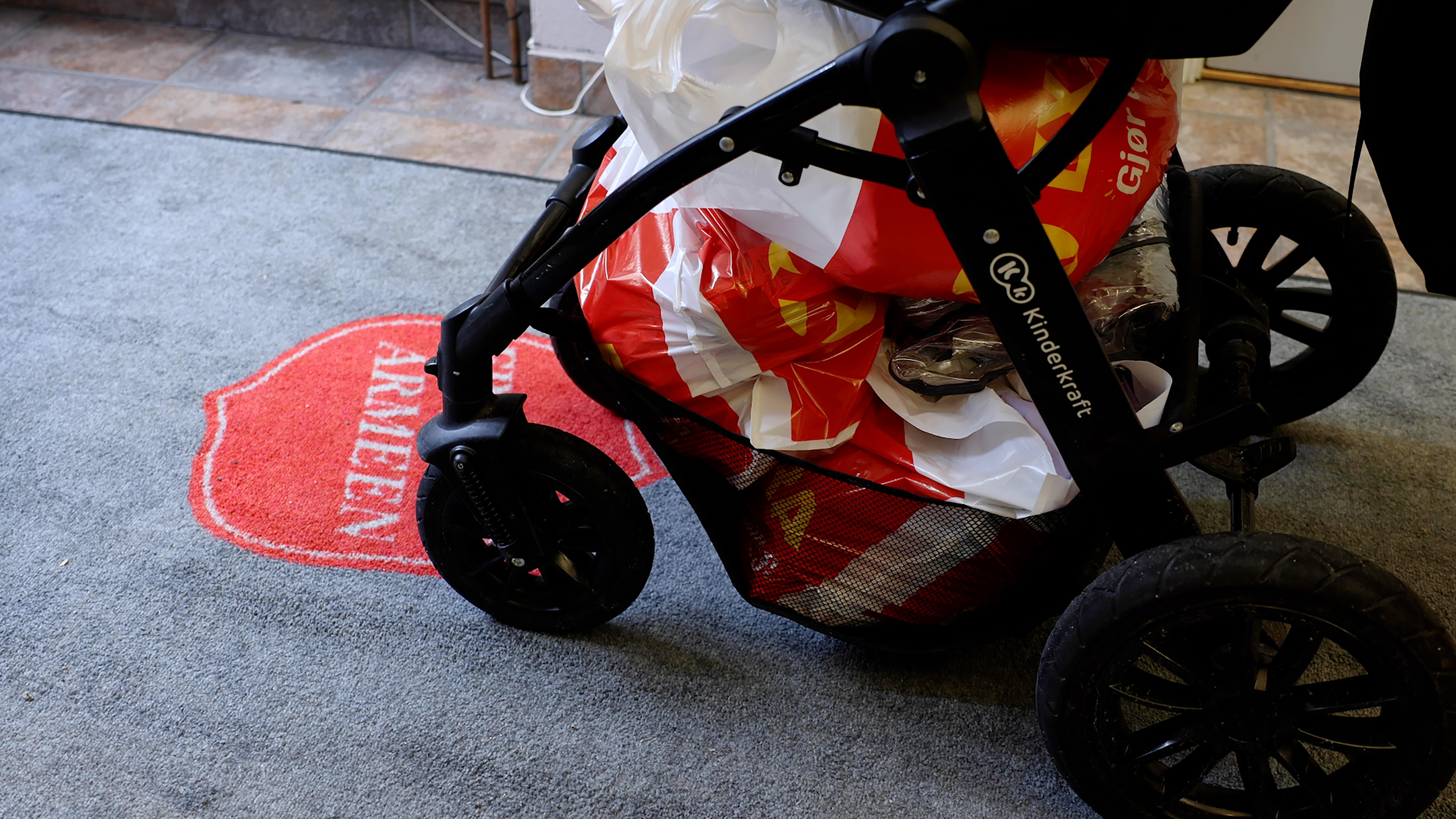 Bæreposer med mat stablet under en barnevogn.