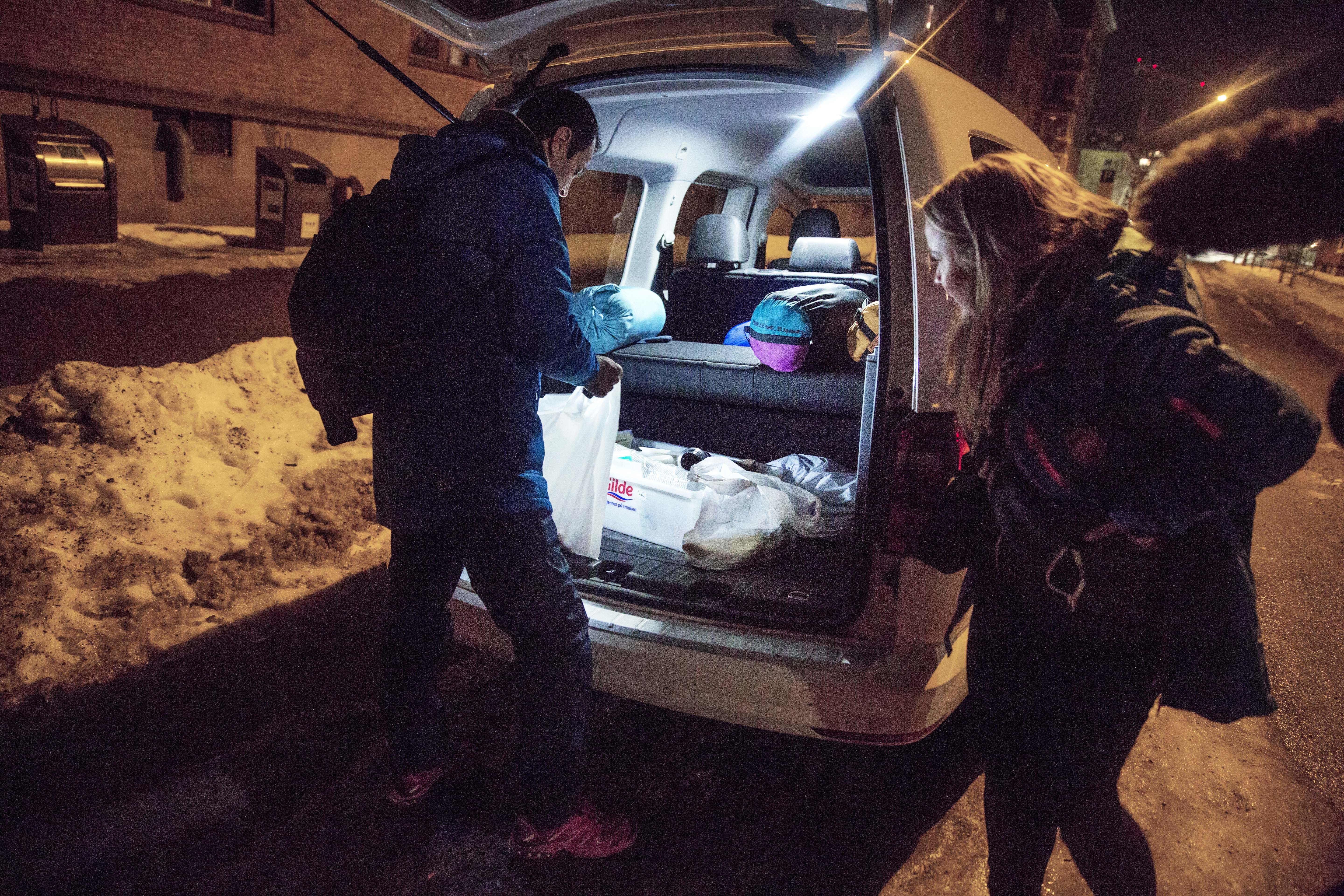 En varebil står med døren åpen. To fra Frelsesarmeens oppsøkende tjeneste finner fram mat og drikke til dem som bor ute på gata.