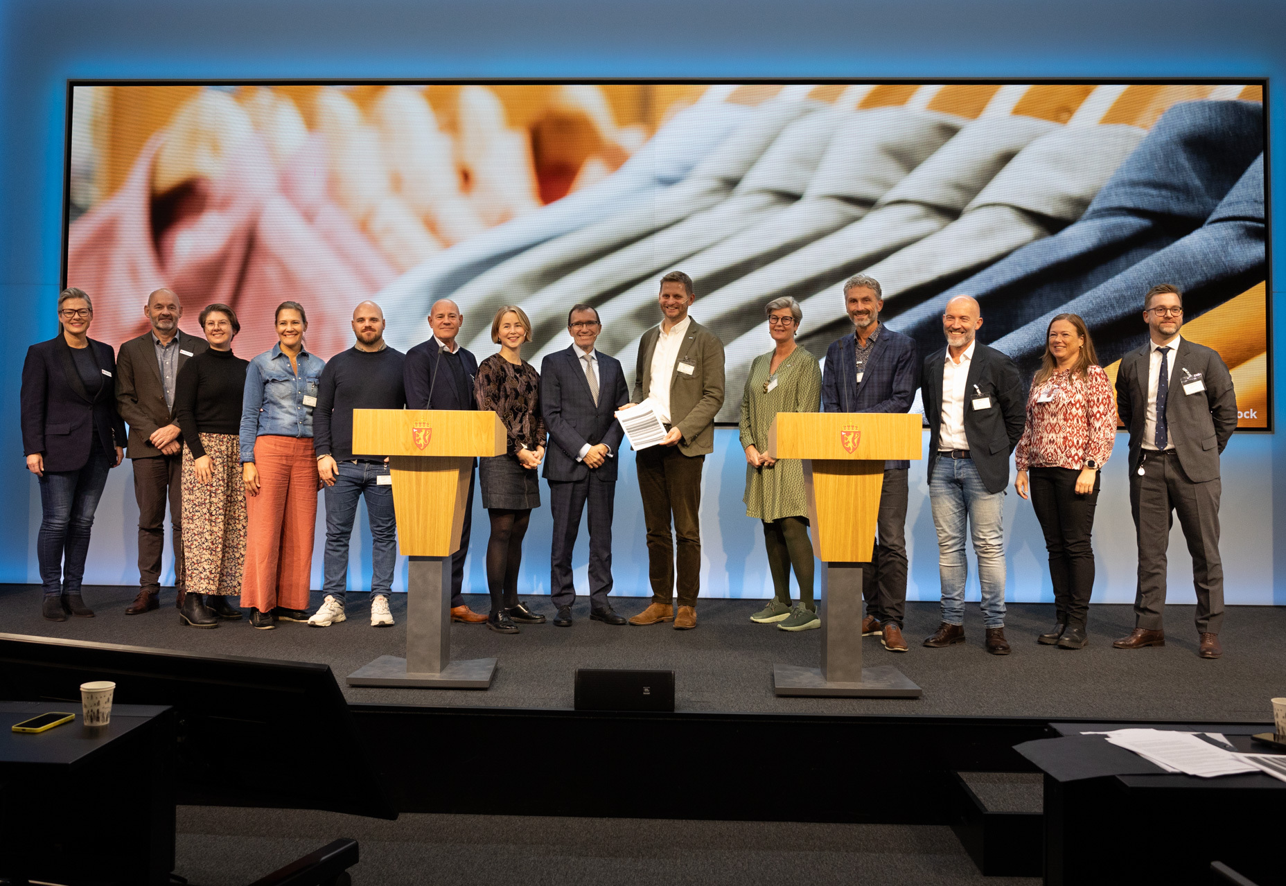 Lang rekke med mennesker som står på begge sider av ministeren.