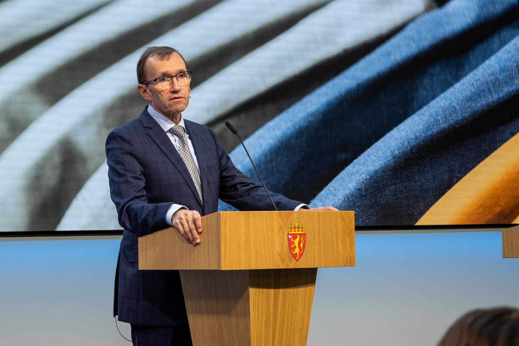 Mann står på talerstol.