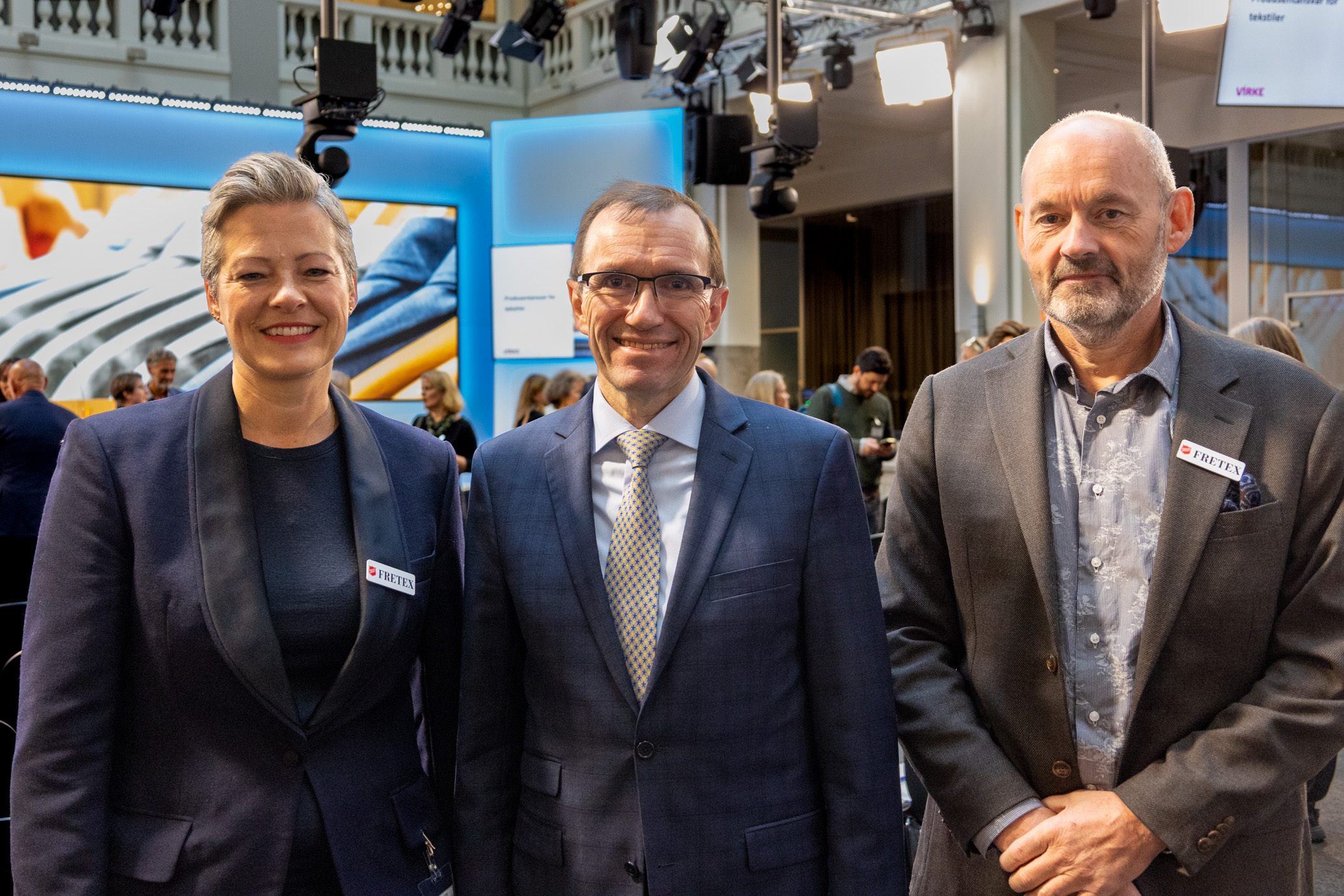 En kvinne og to menn på rekke. I bakgrunnen kan man se en scene.